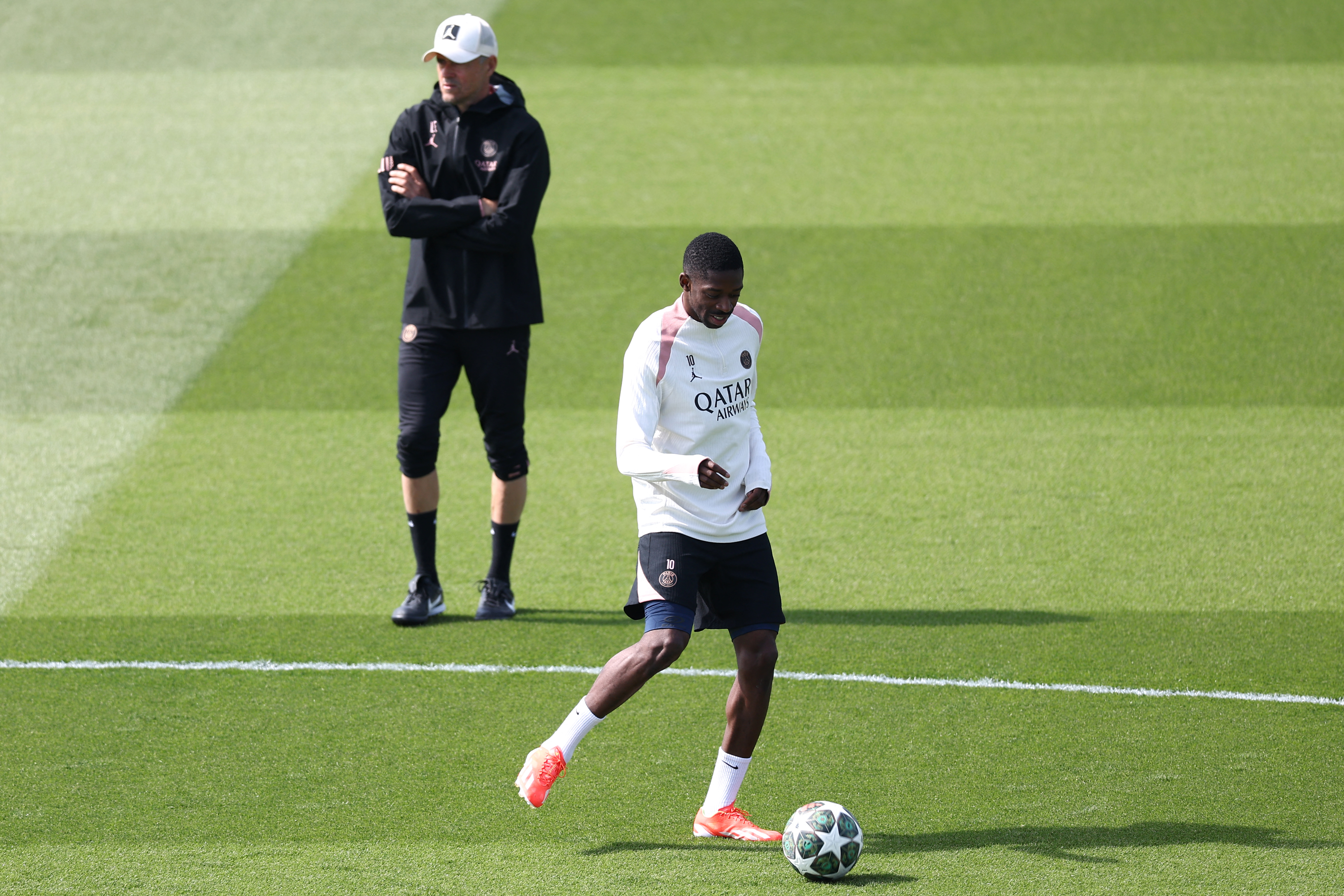 PSG’s French forward #10 Ousmane Dembele, next to head coach Luis Enrique, takes part in a training session on the eve of their second leg semifinal UEFA Champions League match against Arsenal at the club’s training ground in Poissy, west of Paris, on May 6, 2025