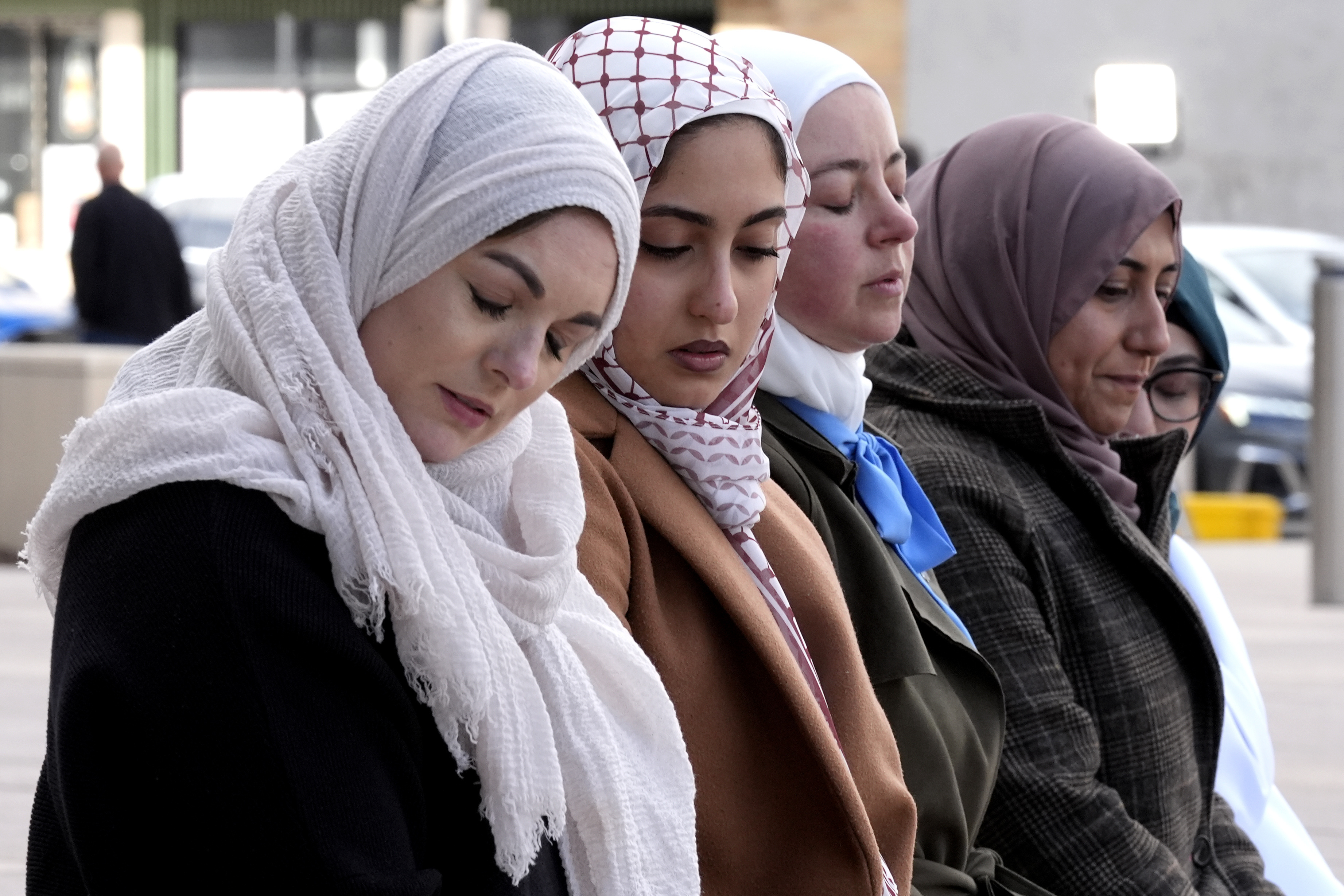 Hela Yousef, second from left, prays for her slain cousin, six-year-old Wadee Alfayoumi, outside the Will County Courthouse on February 28