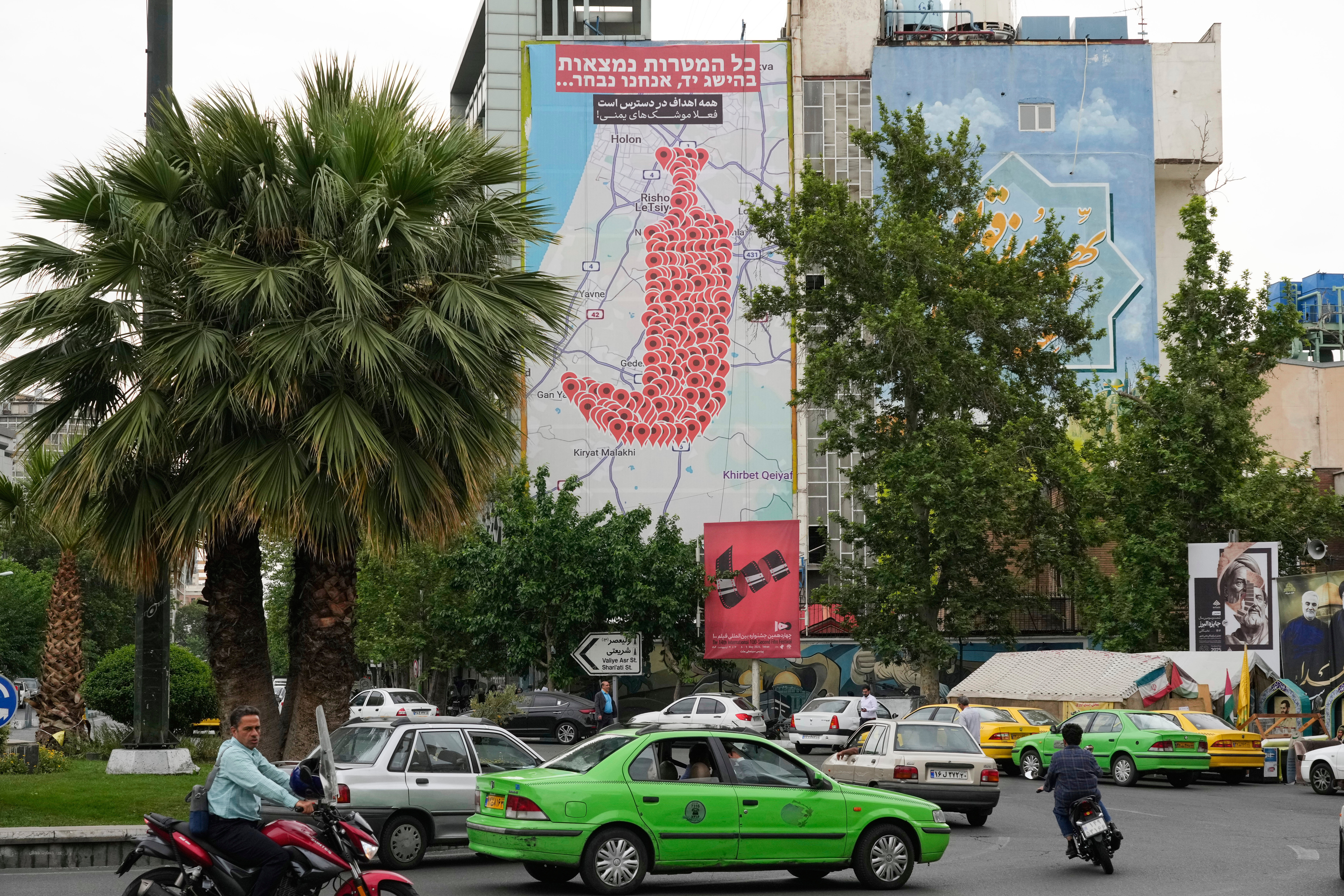 A banner in downtown Tehran’s Palestine Square shows numerous locations in Israel as a Yemeni dagger (jambiya) with writing in Farsi reading: “All targets are within range, Yemeni missiles for now!” and in Hebrew “All targets are within reach, we will choose”, on May 5, 2025