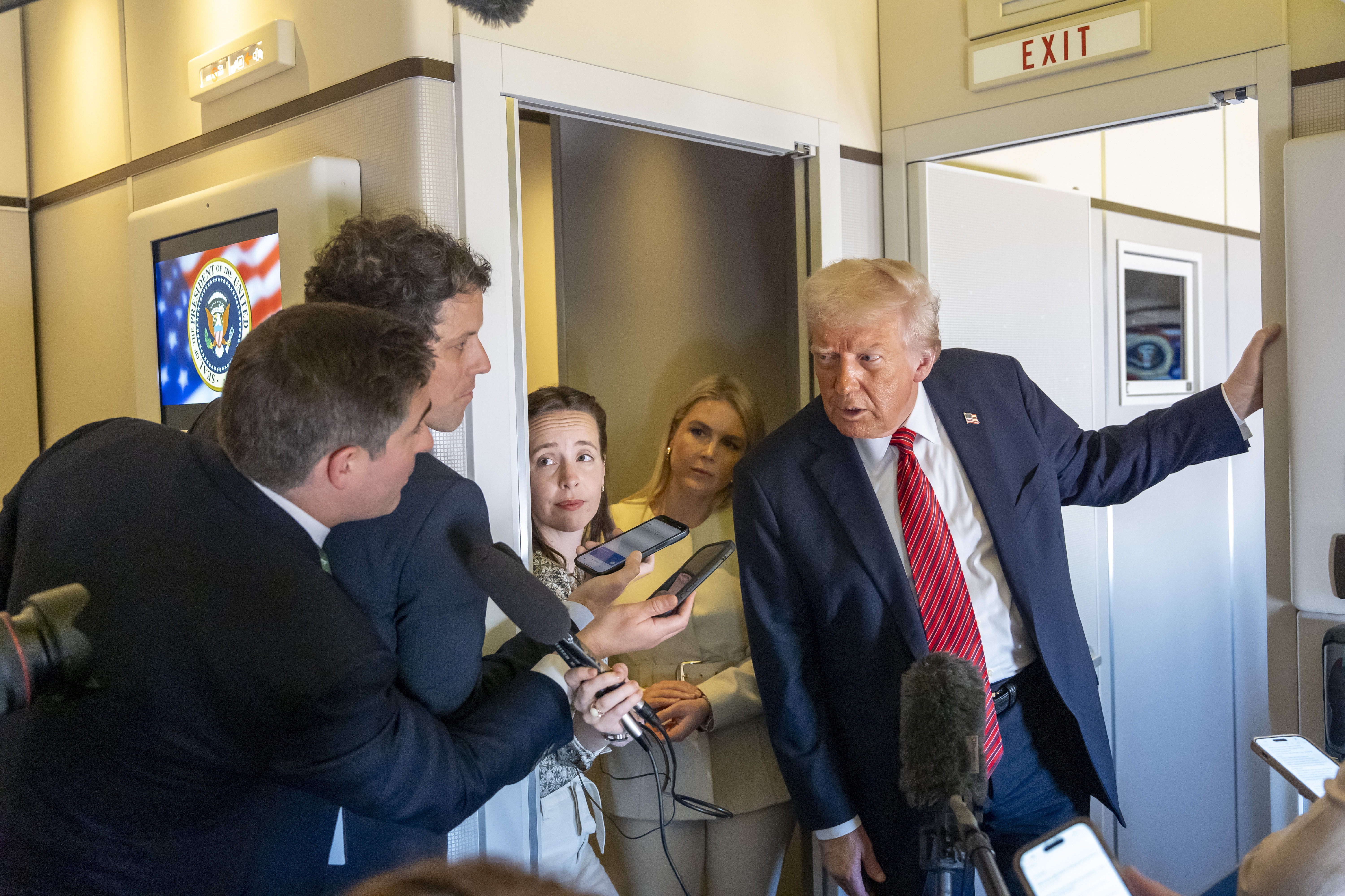 President Donald Trump speaks to reporters on board Air Force One as he flies to Doha
