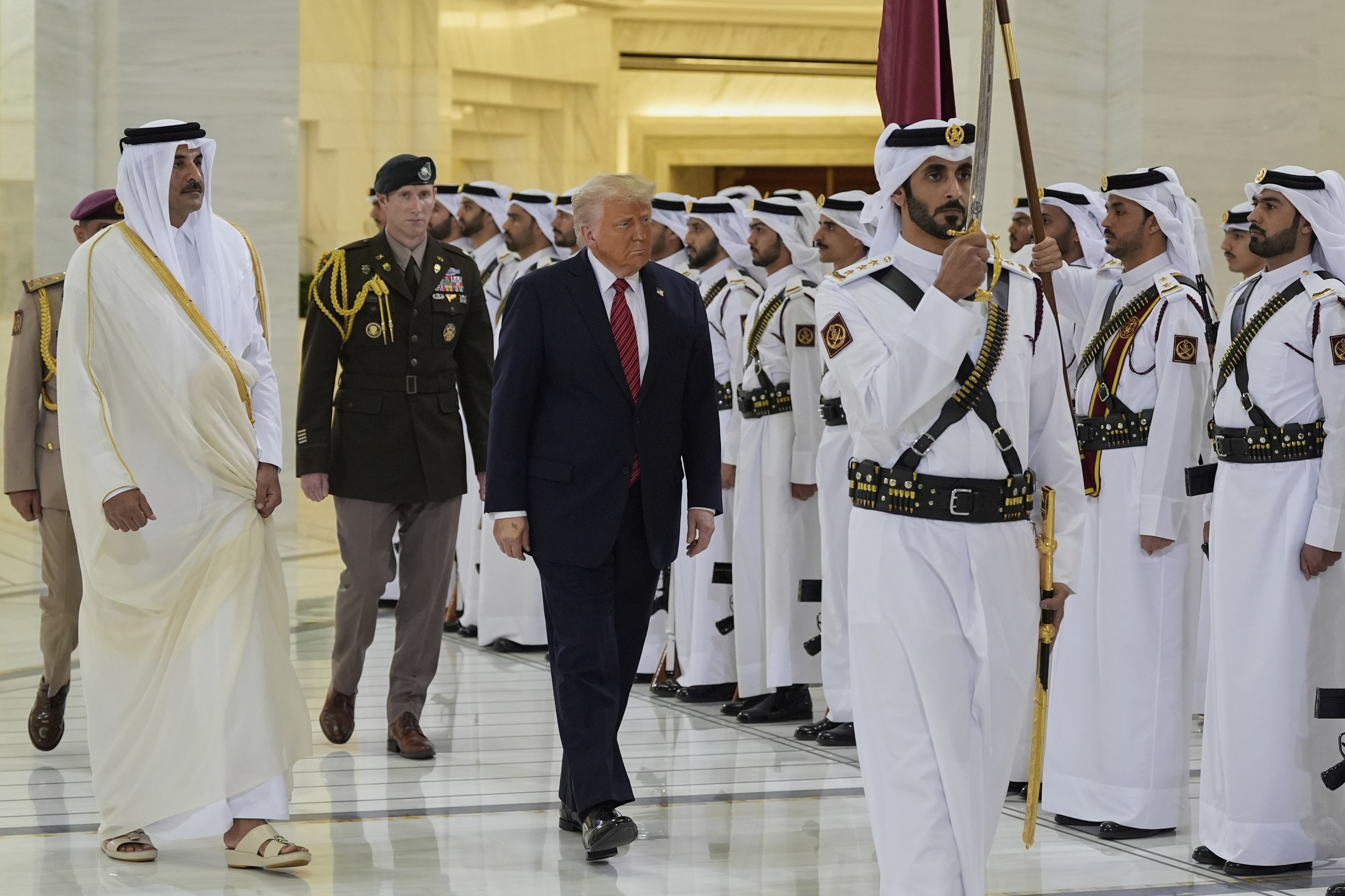 President Donald Trump and Qatar’s Emir Sheikh Tamim bin Hamad Al Thani walk past Qatari honour guard in Doha, Qatar