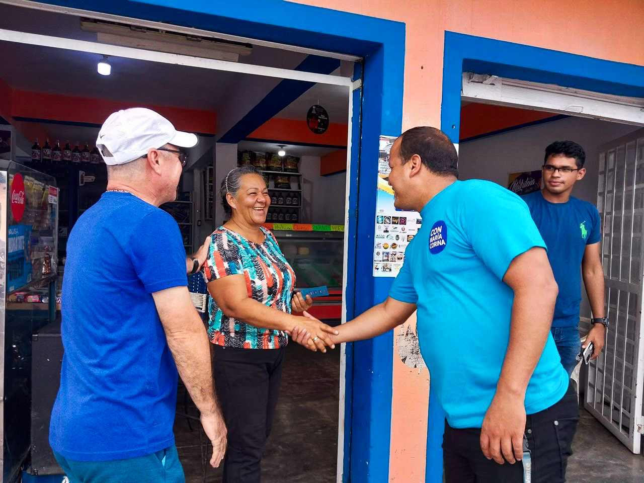 Orlando Moreno shakes hands with a constituent who is framed by a door