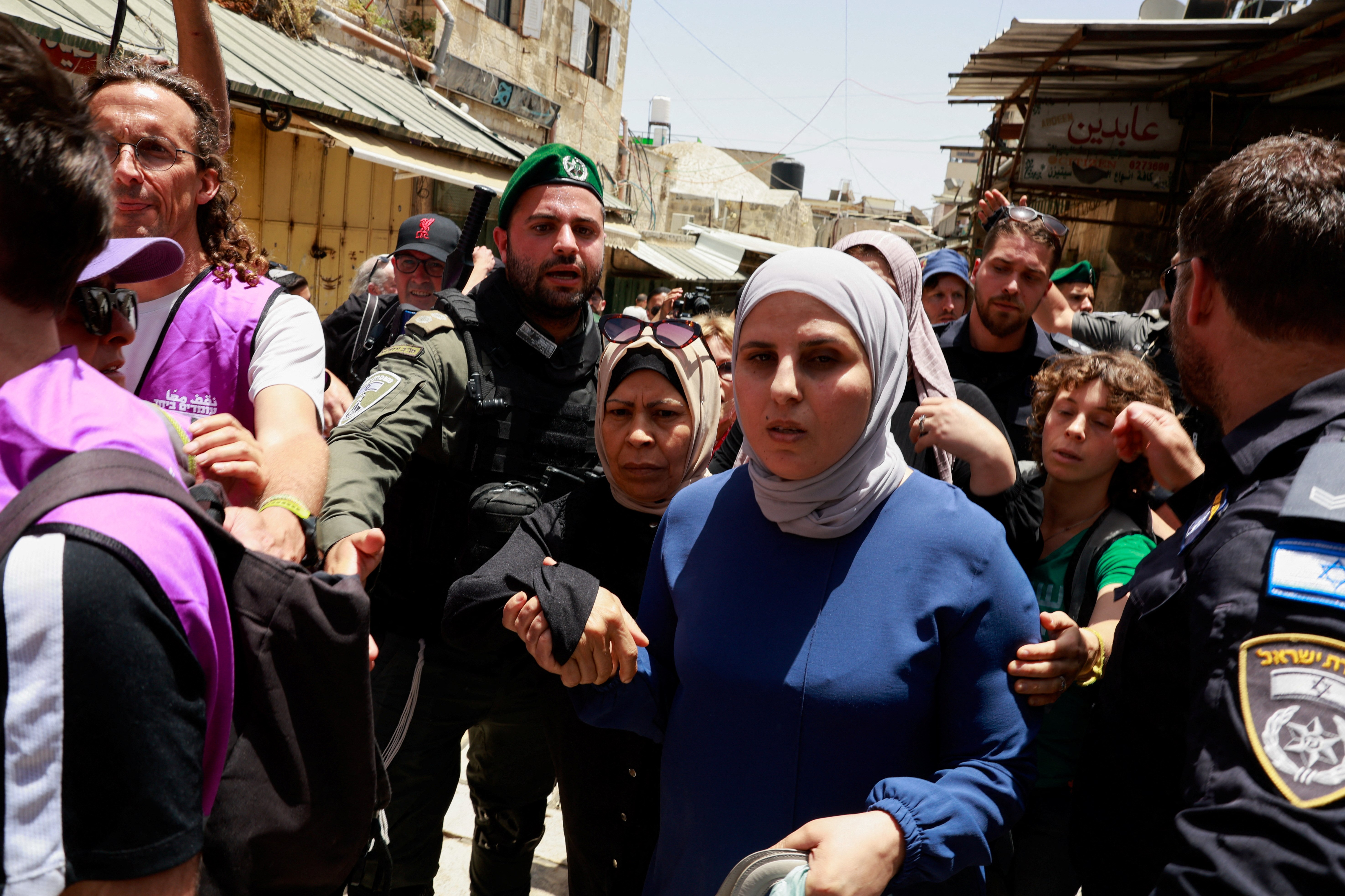 Palestinian women walk past Israeli police, on Jerusalem Day, in Jerusalem's Old City, May 26, 2025. REUTERS/Ammar Awad