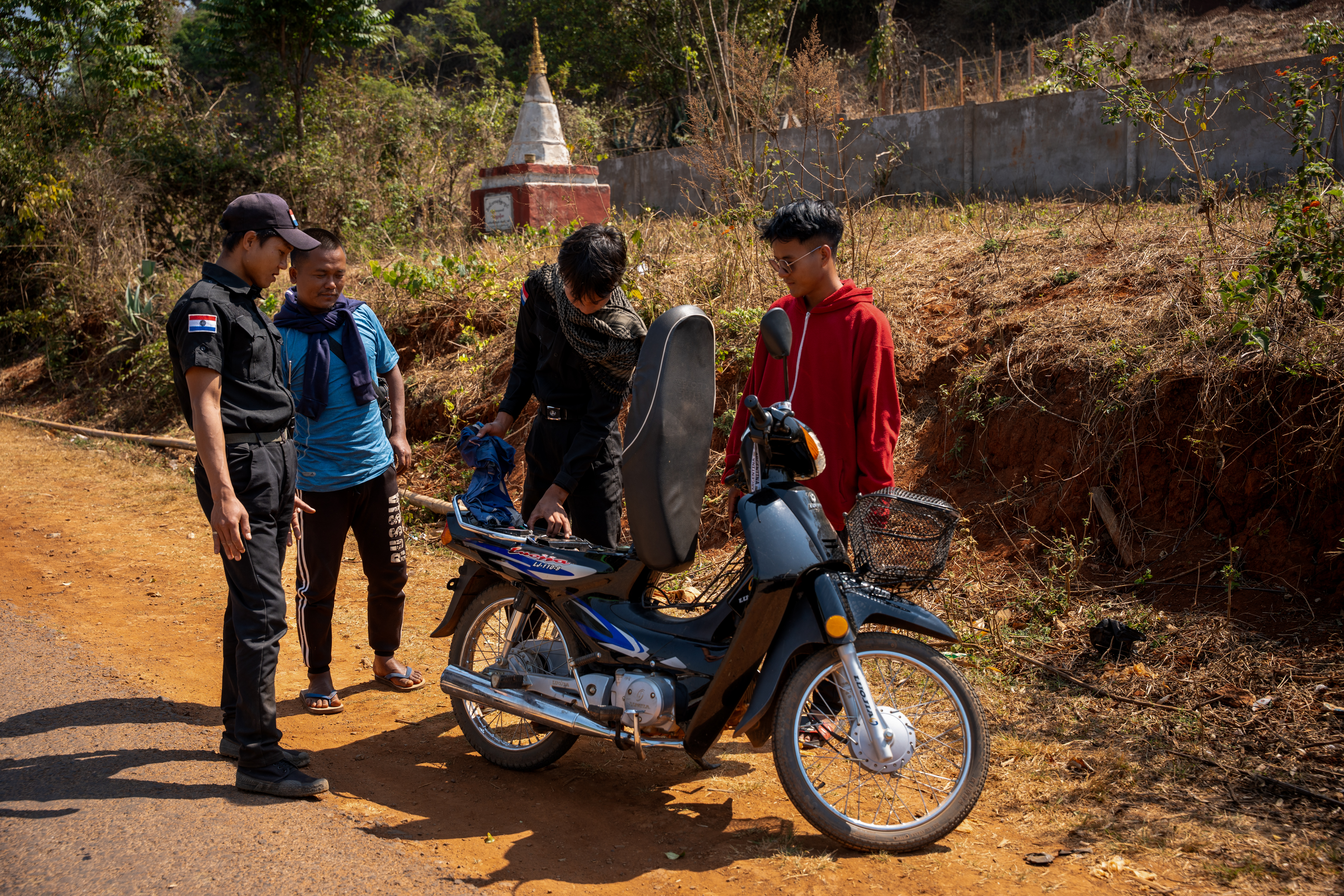 Karenni police officers search a motorbike at a checkpoint in Pekon district, southern Shan State