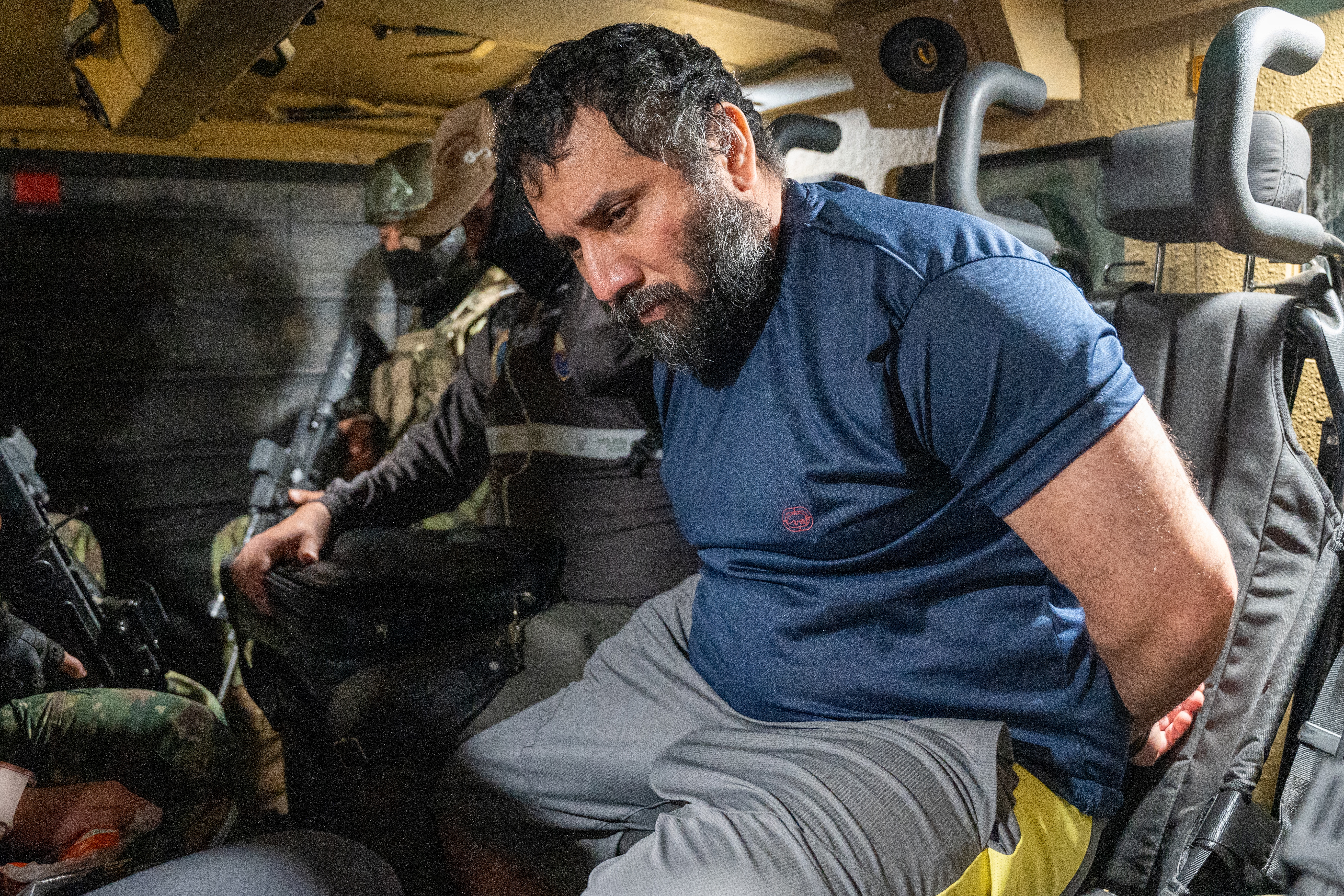 epa12198026 Drug trafficker Jose Adolfo Macias Villamar 'Fito' (R) is guarded as he is moved in Guayaquil, Ecuador, 25 June 2025. 'Fito' arrived at the Guayaquil Air Base after being captured in the city of Manta, and will be held in the maximum security prison La Roca. EPA/MAURICIO TORRES