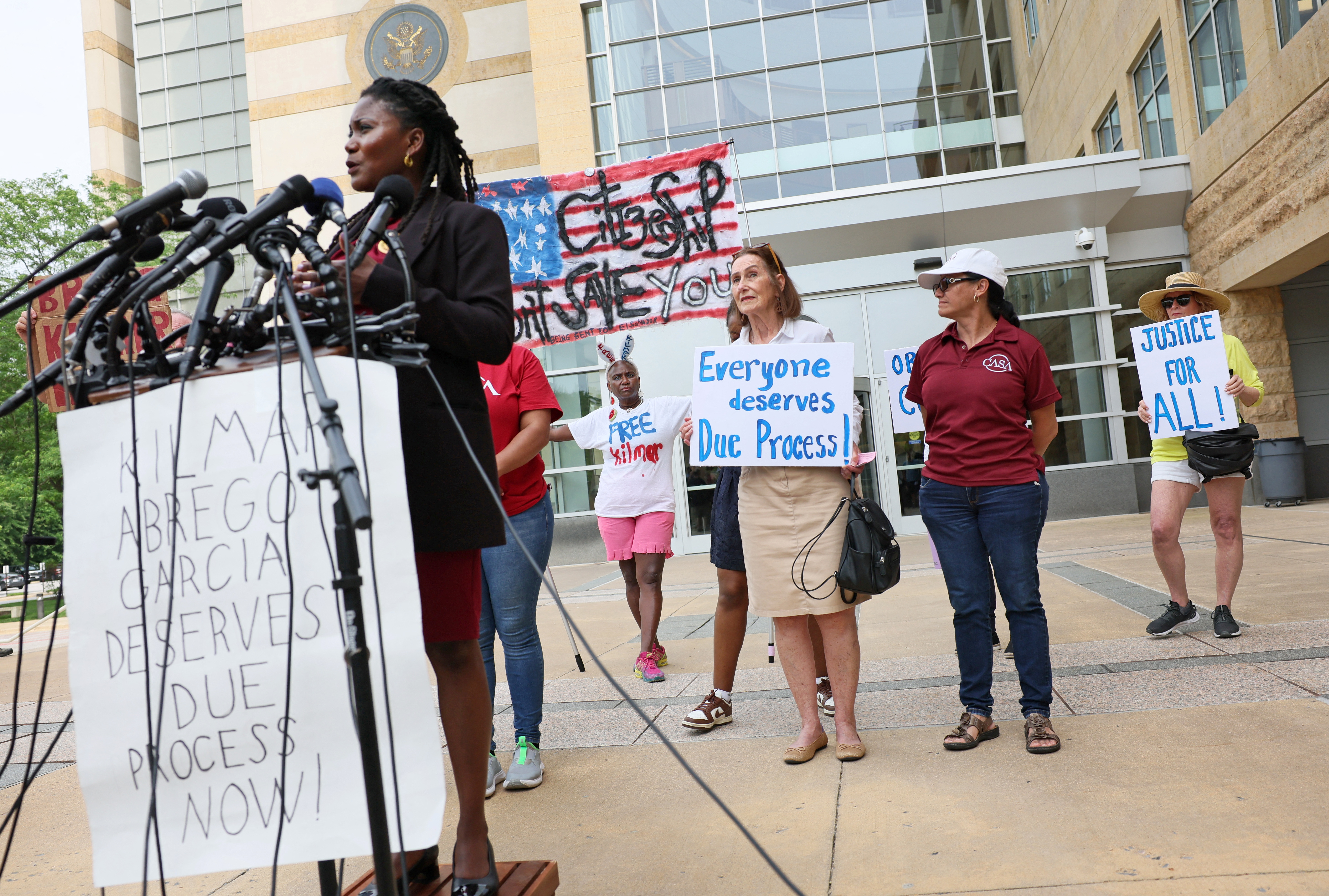 Ama Frimpong speaks at a podium outside a Maryland federal court.