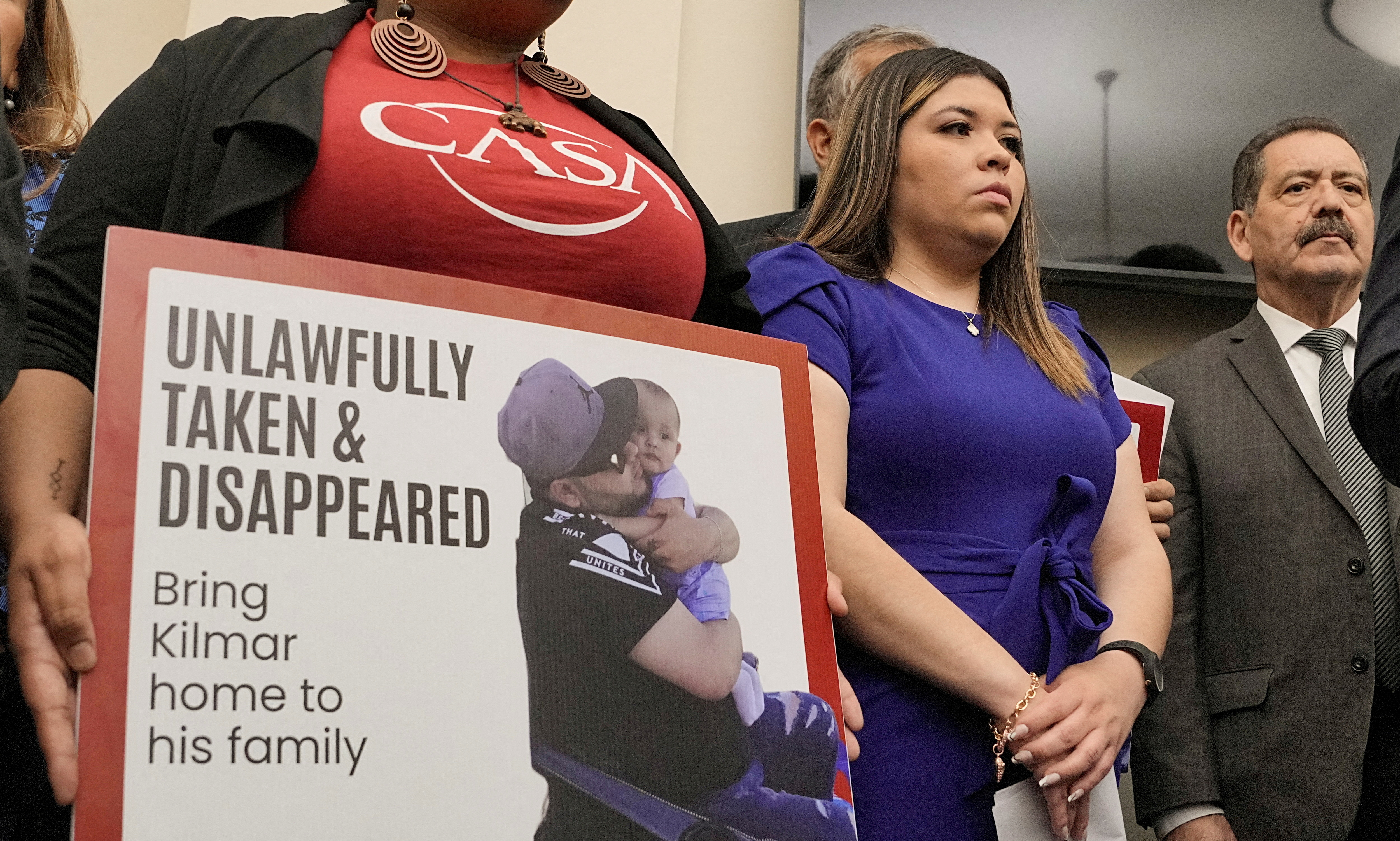 A protester holds up a photo of Abrego Garcia hugging his child, with the caption: "Unlawfully taken and disappeared."