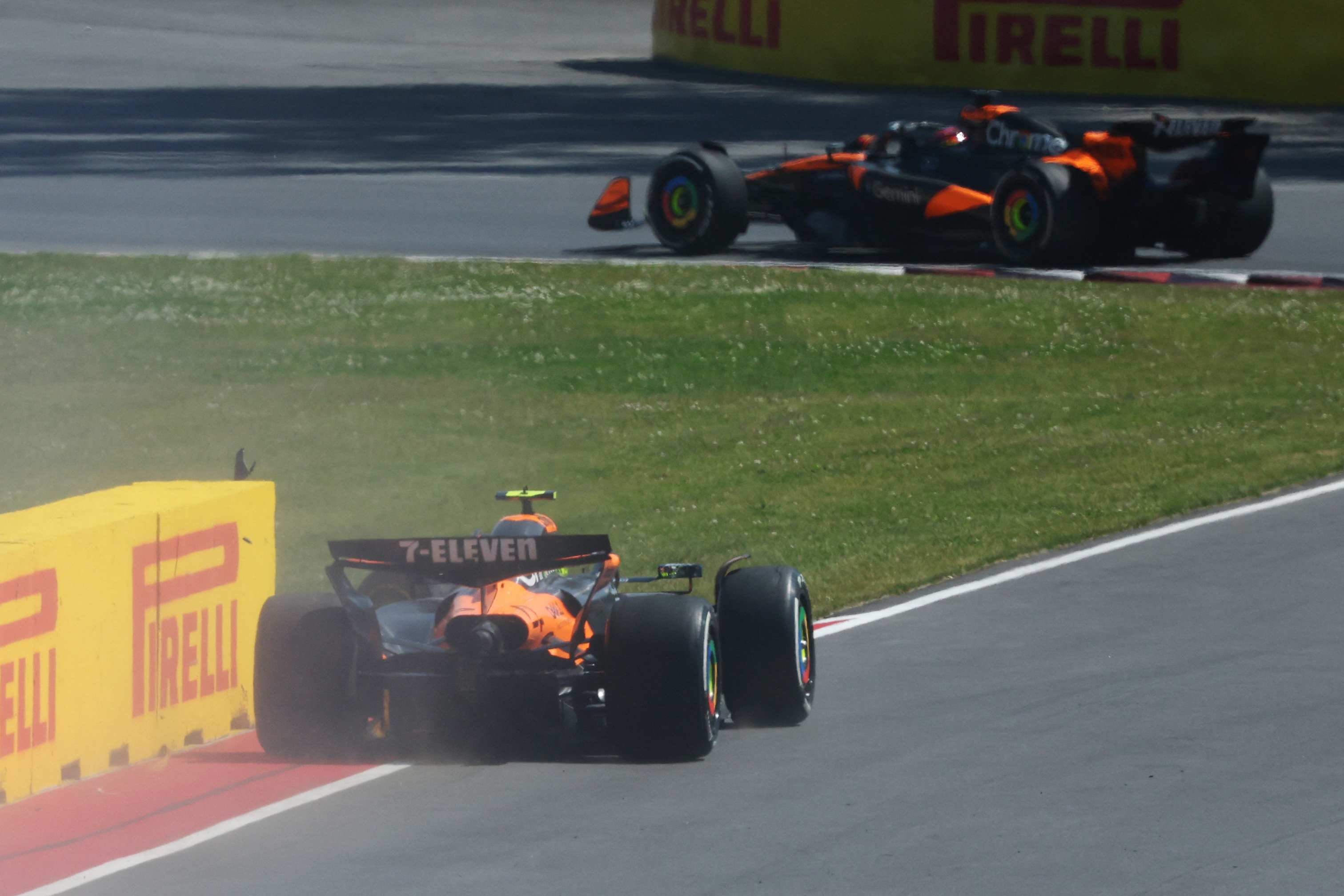 McLaren driver Lando Norris, left, on the side of the track after crashing into teammate Oscar Piastri, top of screen, on lap 67 of the Canadian Grand Prix