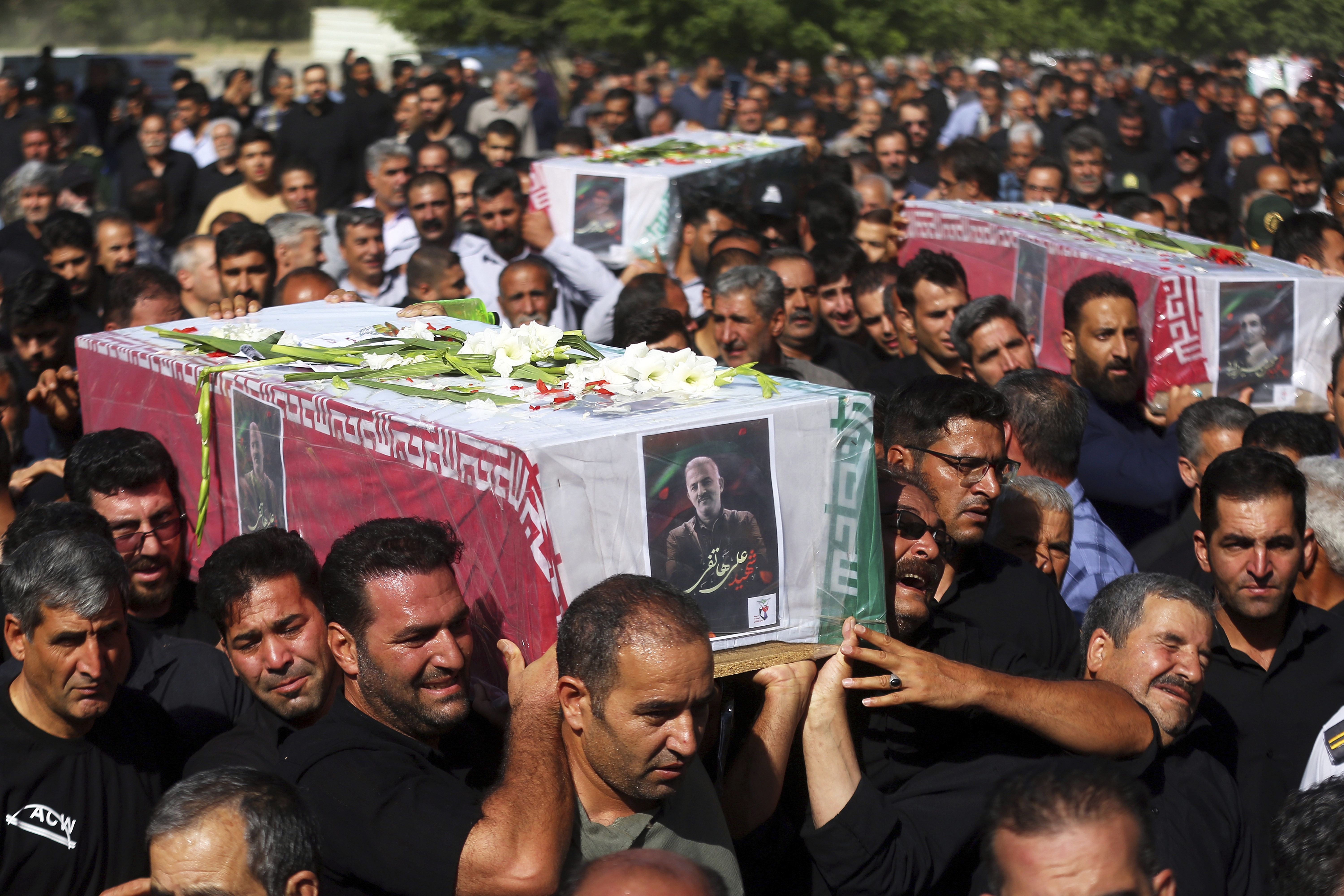 Mourners carry bodies in coffins through the streets of Tehran.