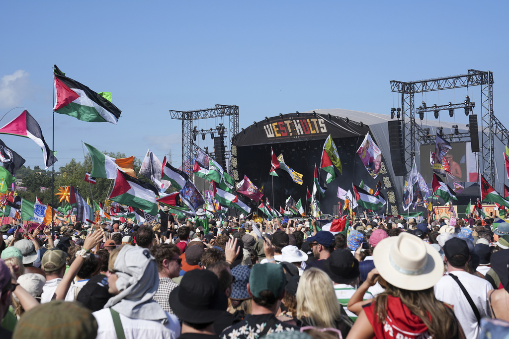 Festival-goers wave Palestinian flags during Kneecap’s Glastonbury set