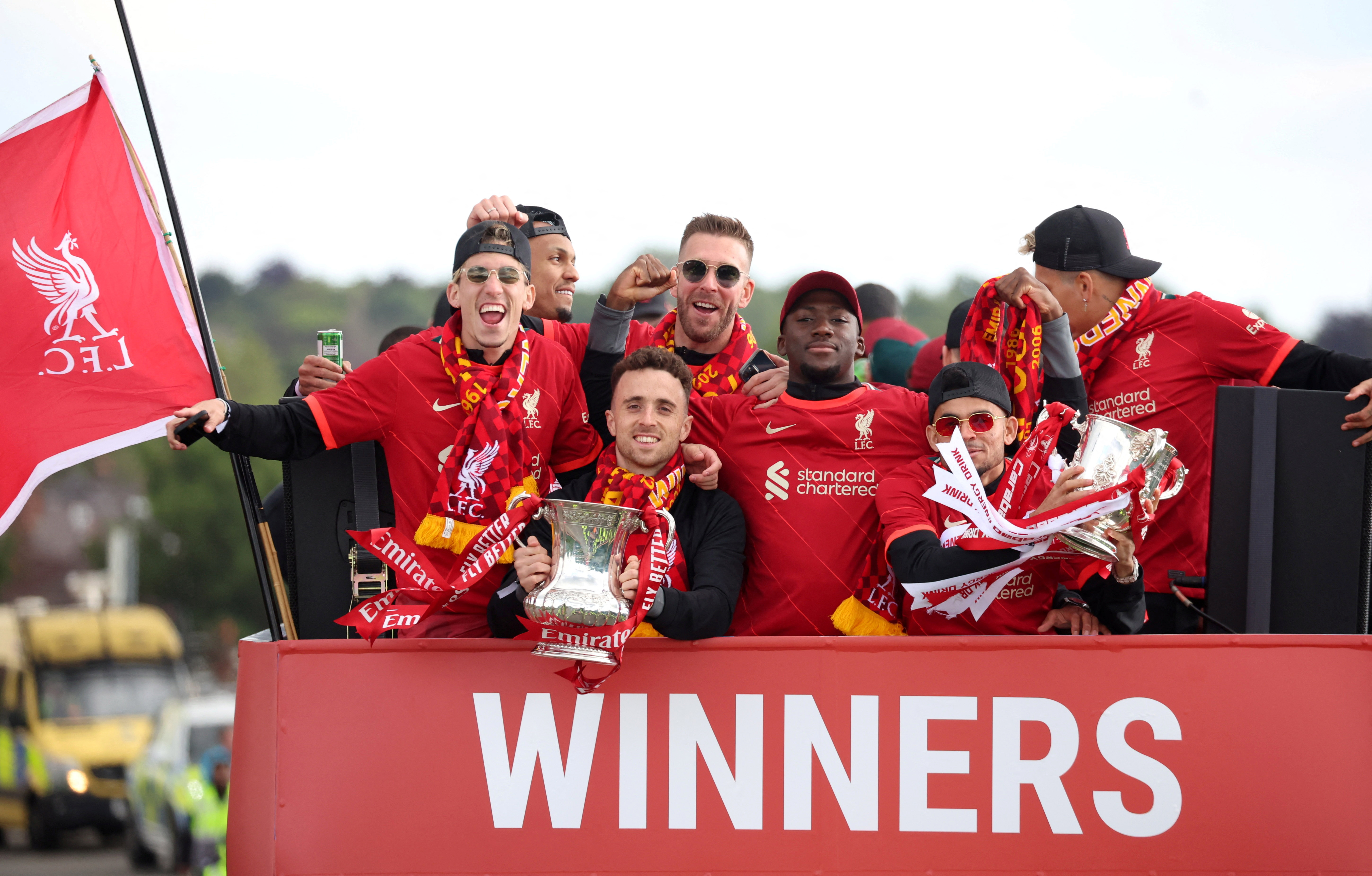 Liverpool’s late Diogo Jota, bottom left, and Luis Diaz, bottom right, celebrate with the FA Cup and the Carabao Cup trophies during a bus parade in May 2022
