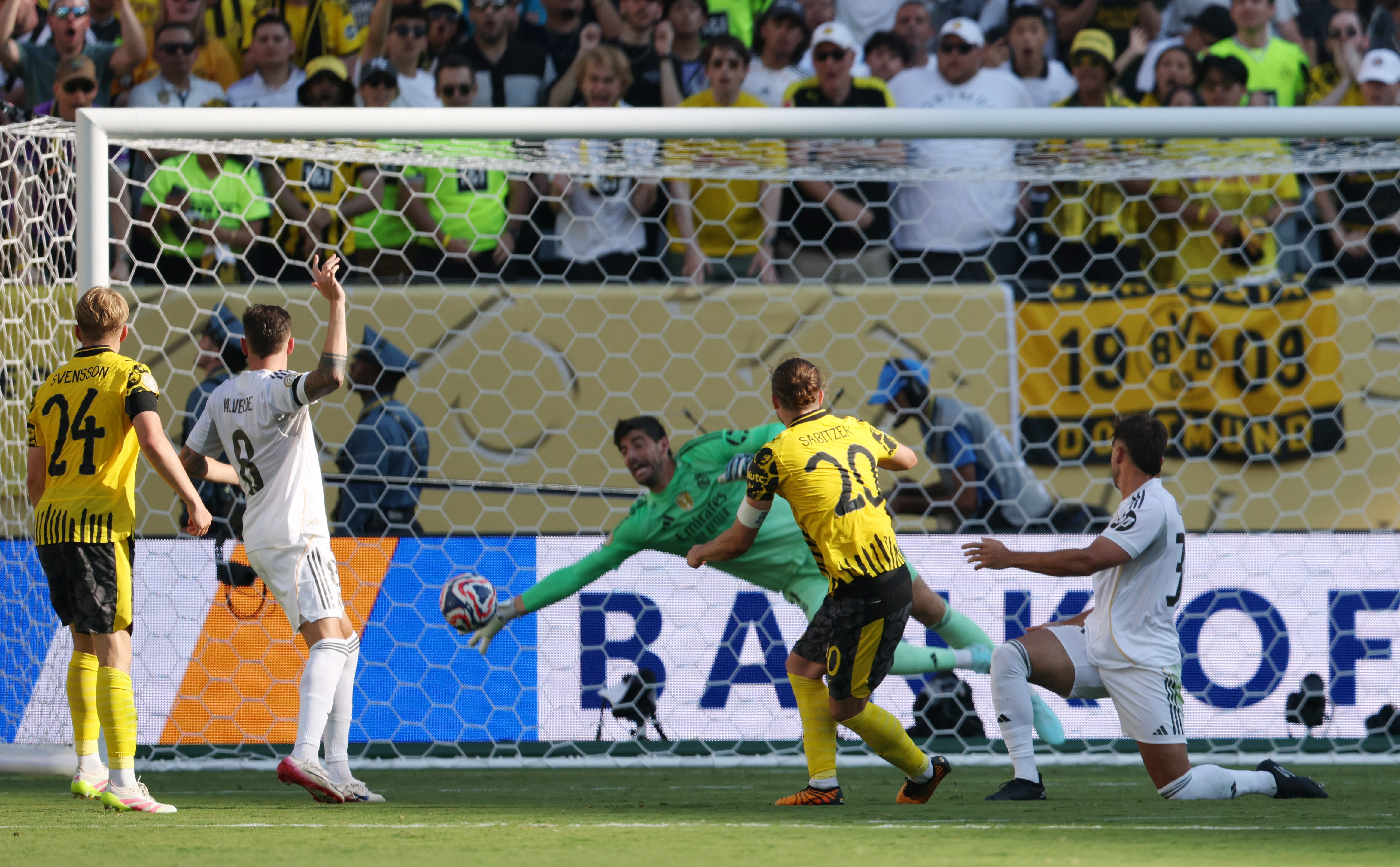 Real Madrid’s Thibaut Courtois saves a shot from Borussia Dortmund’s Marcel Sabitzer