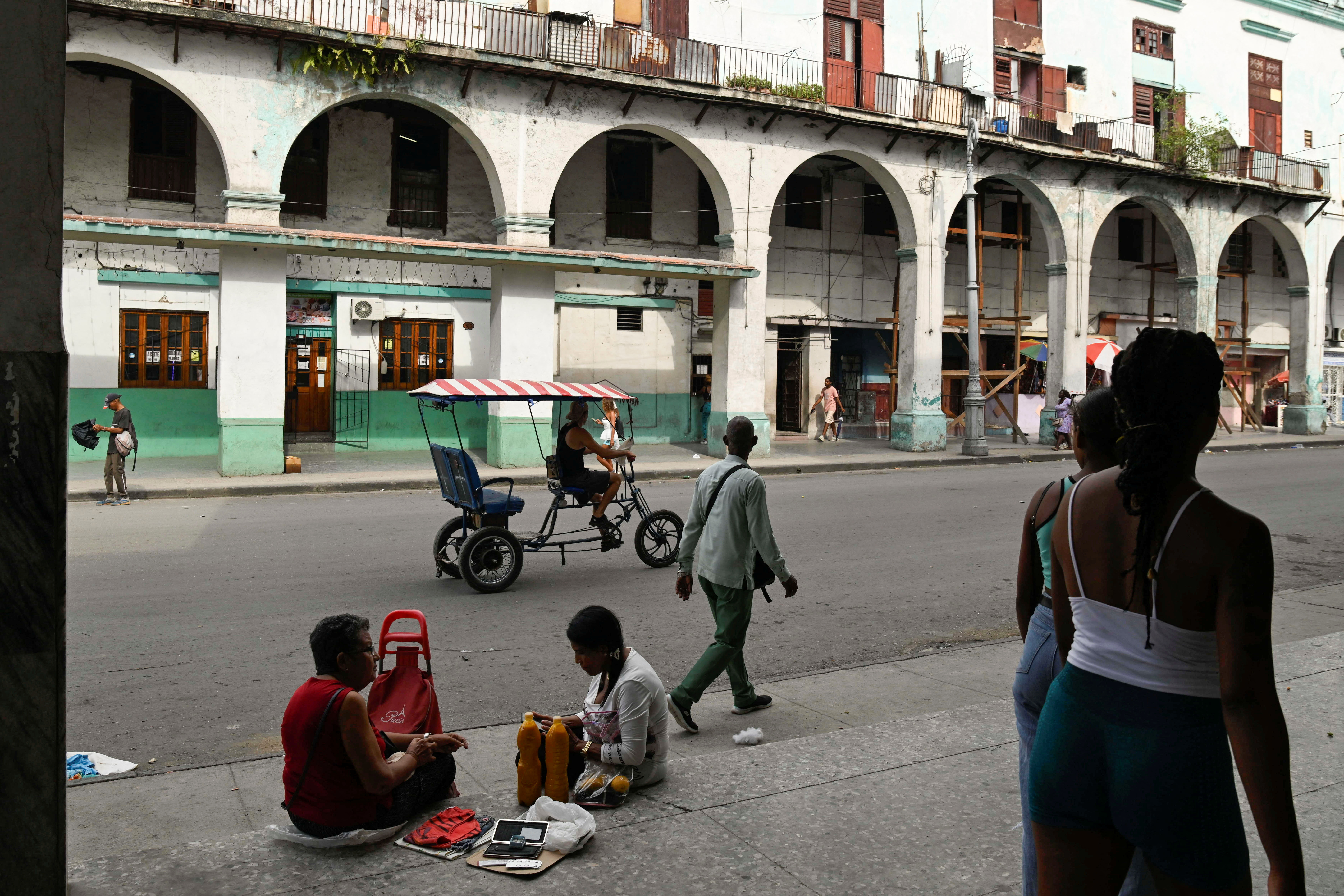 A woman sells goods on a pavement in Havana, Cuba, on July 15, 2025