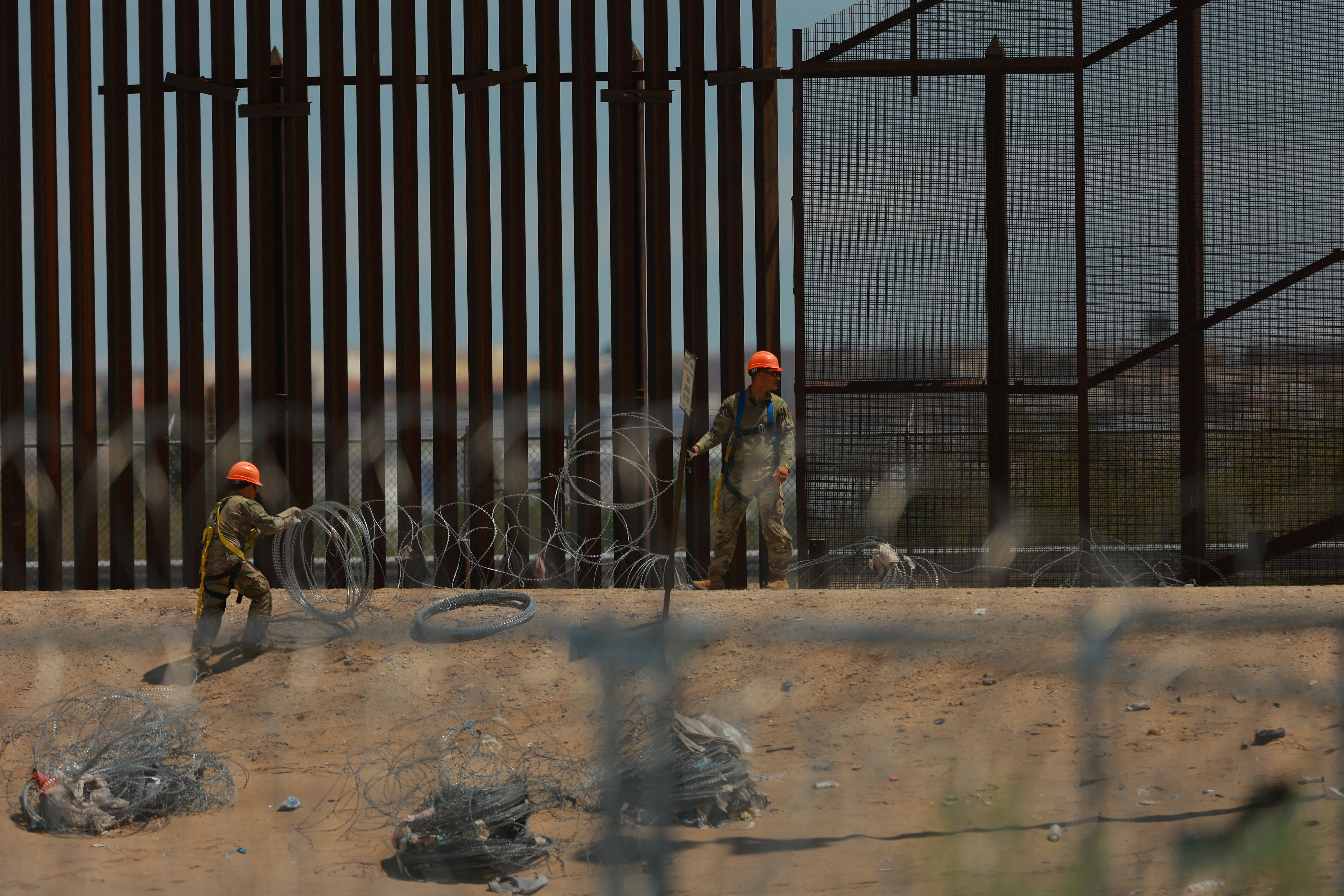U.S. Army combat engineers place razor wire on the U.S.-Mexico border wall to reinforce security in El Paso Texas, as seen from Ciudad Juarez, Mexico July 23, 2025. REUTERS/Jose Luis Gonzalez