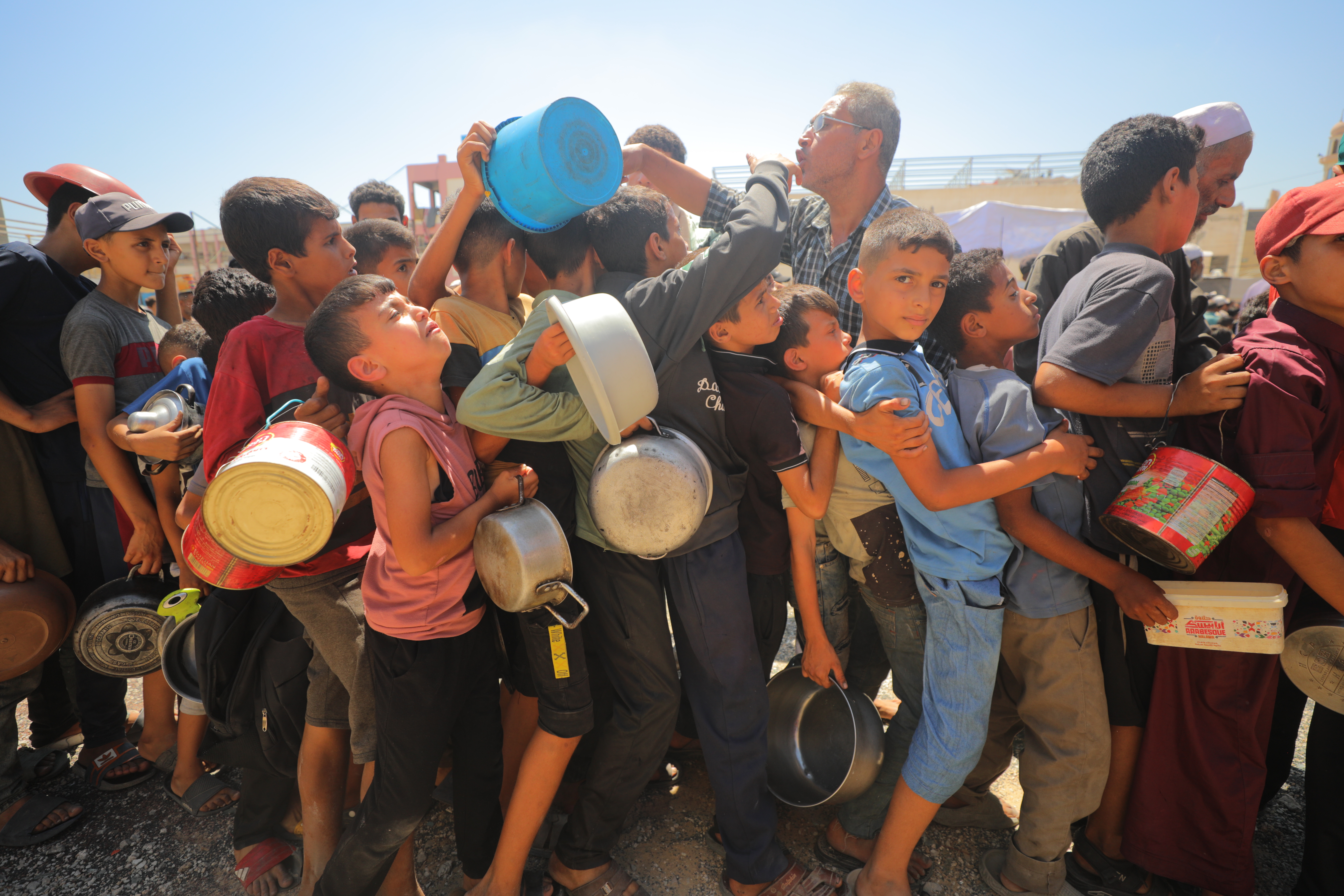 People of Gaza have been displaced over and over, and are being starved by Israel, which blocks aid as it continues bombing the displaced. Here, hungry children line up for food aid at the Nuseirat refugee camp on July 13, 2025
