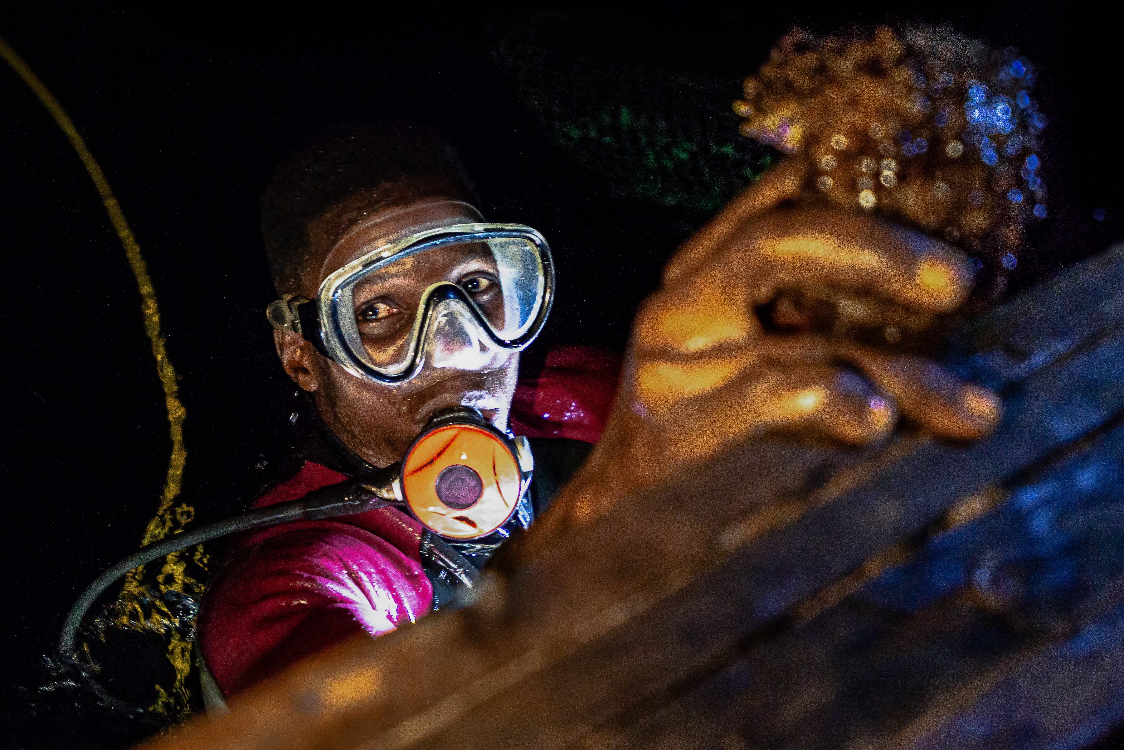 Olomode Jones with a sea cucumber [Olivia Acland/Al Jazeera]