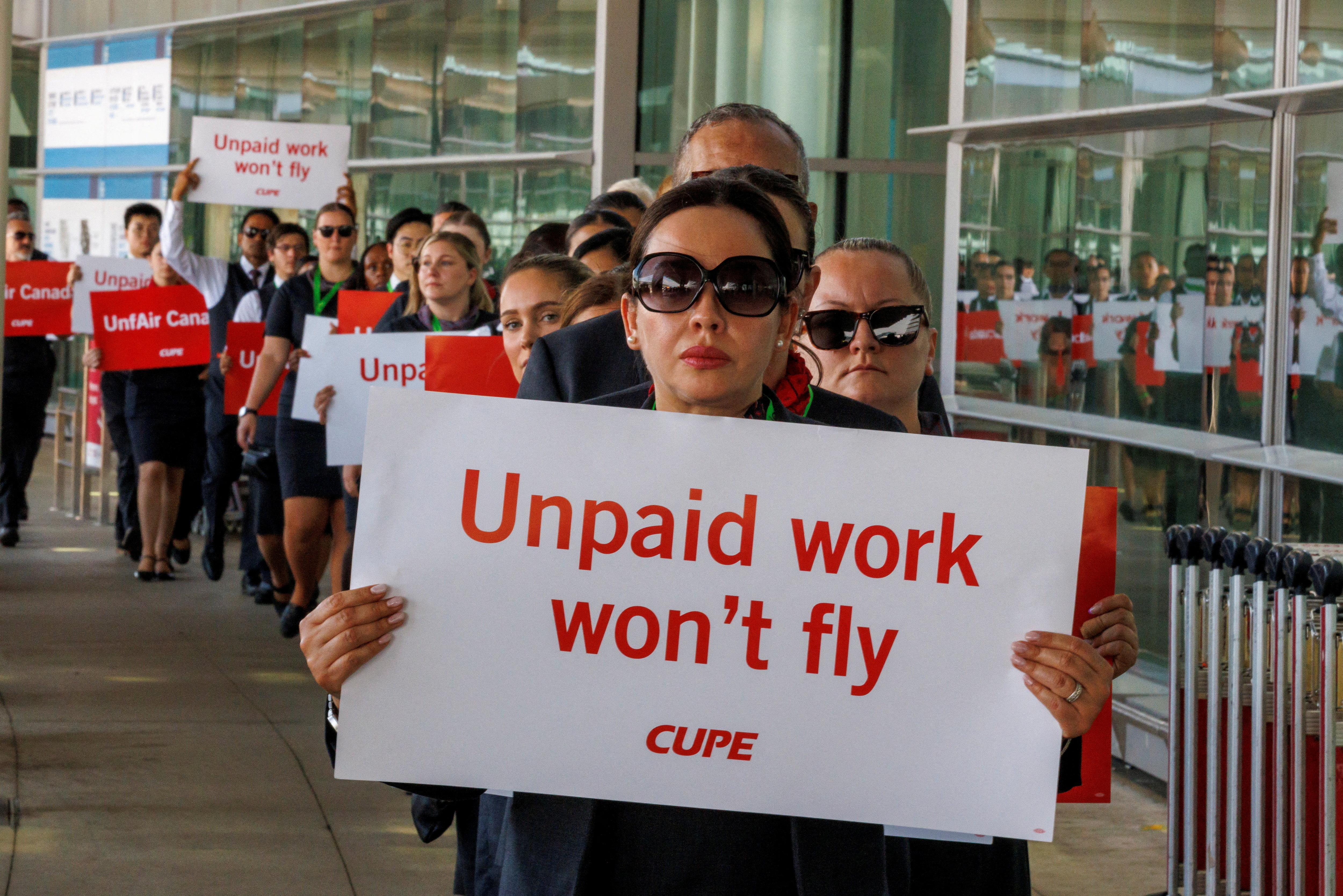 Air Canada flight attendants, represented by the Canadian Union of Public Employees, form a picket line at the Toronto Pearson international airport on August 11