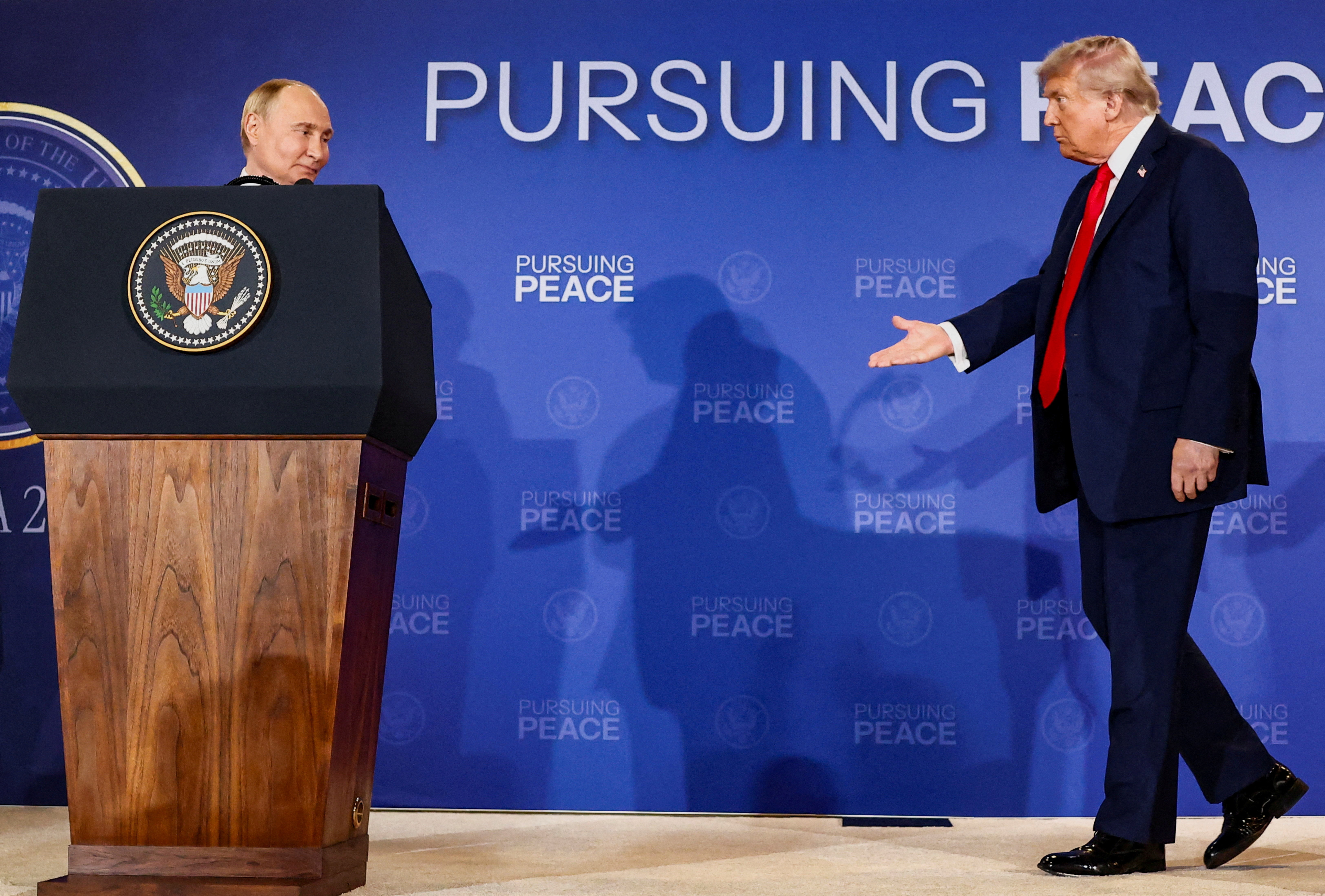 U.S. President Donald Trump walks towards Russian President Vladimir Putin during a press conference following their meeting to negotiate an end to the war in Ukraine, at Joint Base Elmendorf-Richardson, in Anchorage, Alaska, U.S., August 15, 2025. REUTERS/Kevin Lamarque TPX IMAGES OF THE DAY
