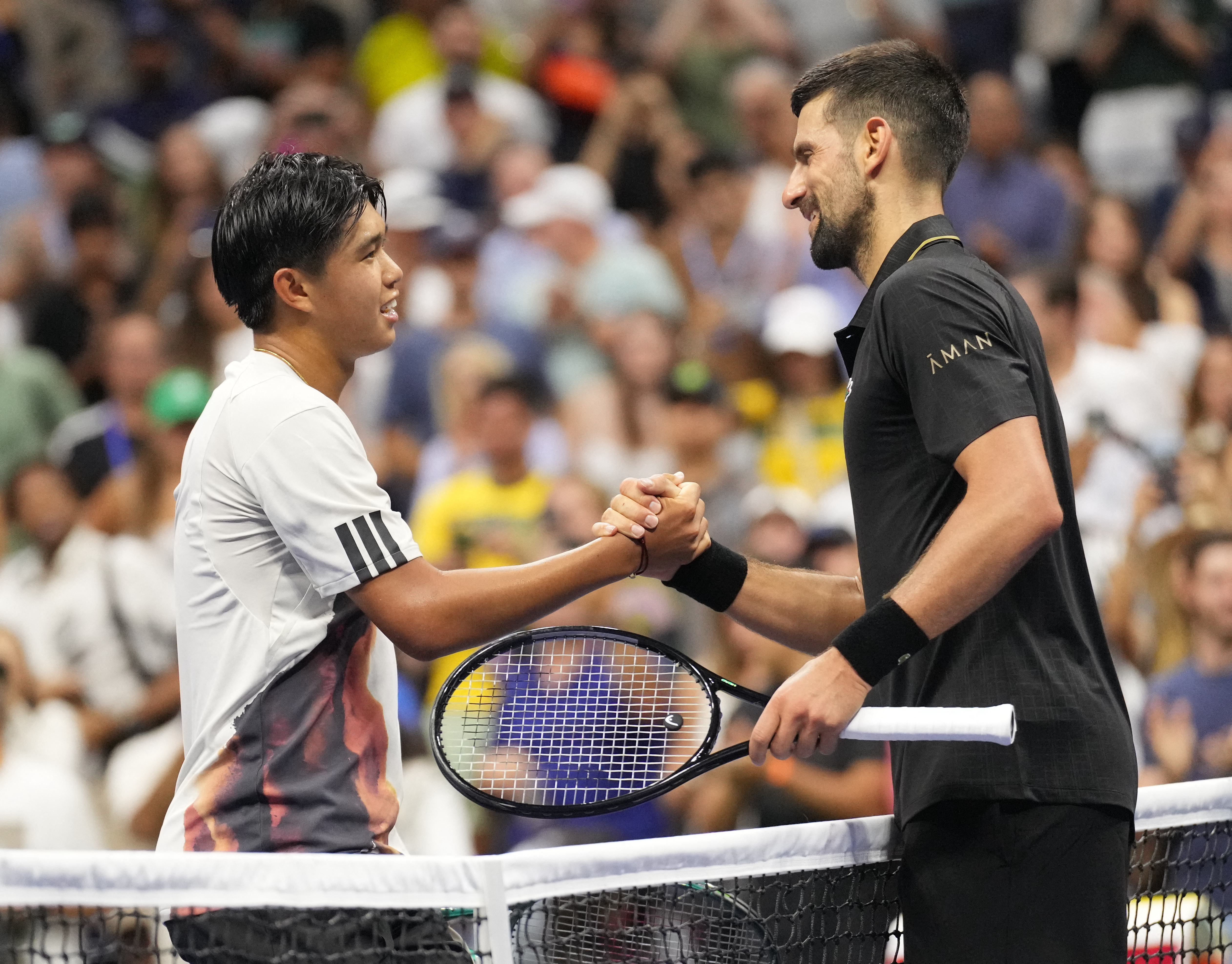 Novak Djokovic, right, shakes hands with Learner Tien after their first-round match