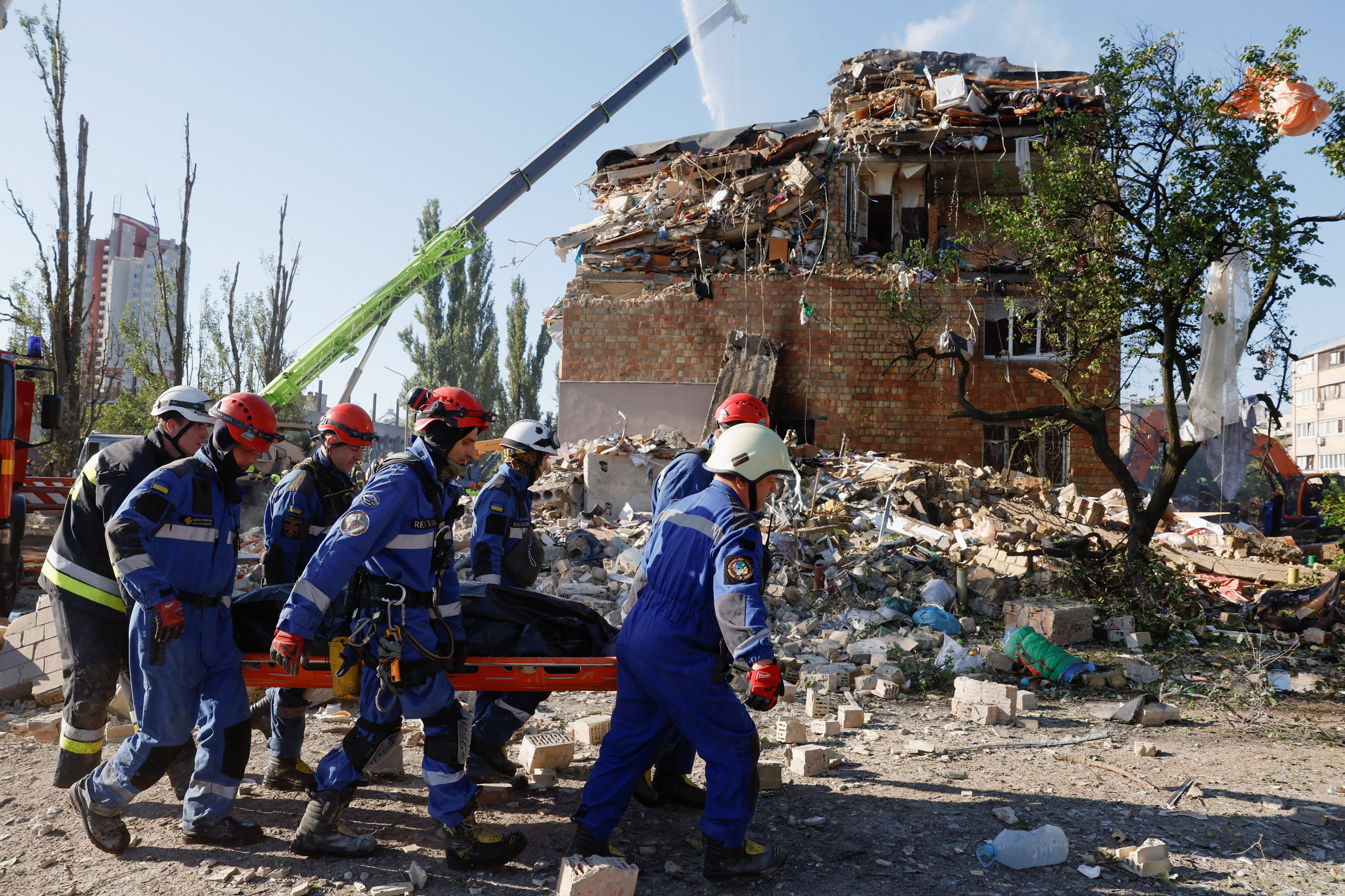 Rescuers carry a casualty at the site of a building that was hit during Russian missile and drone strikes on Kyiv on Thursday