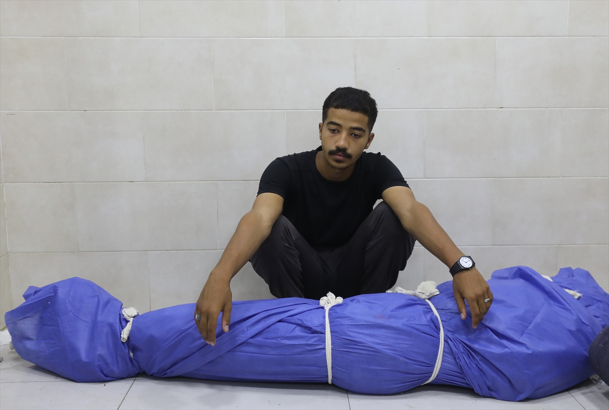Relatives of Palestinians mourn over the dead body of a Palestinian who was killed after Israeli forces opened fire on Palestinians waiting for aid in the Netzarim Corridor of the Gaza Strip [File: Moiz Salhi/Anadolu]