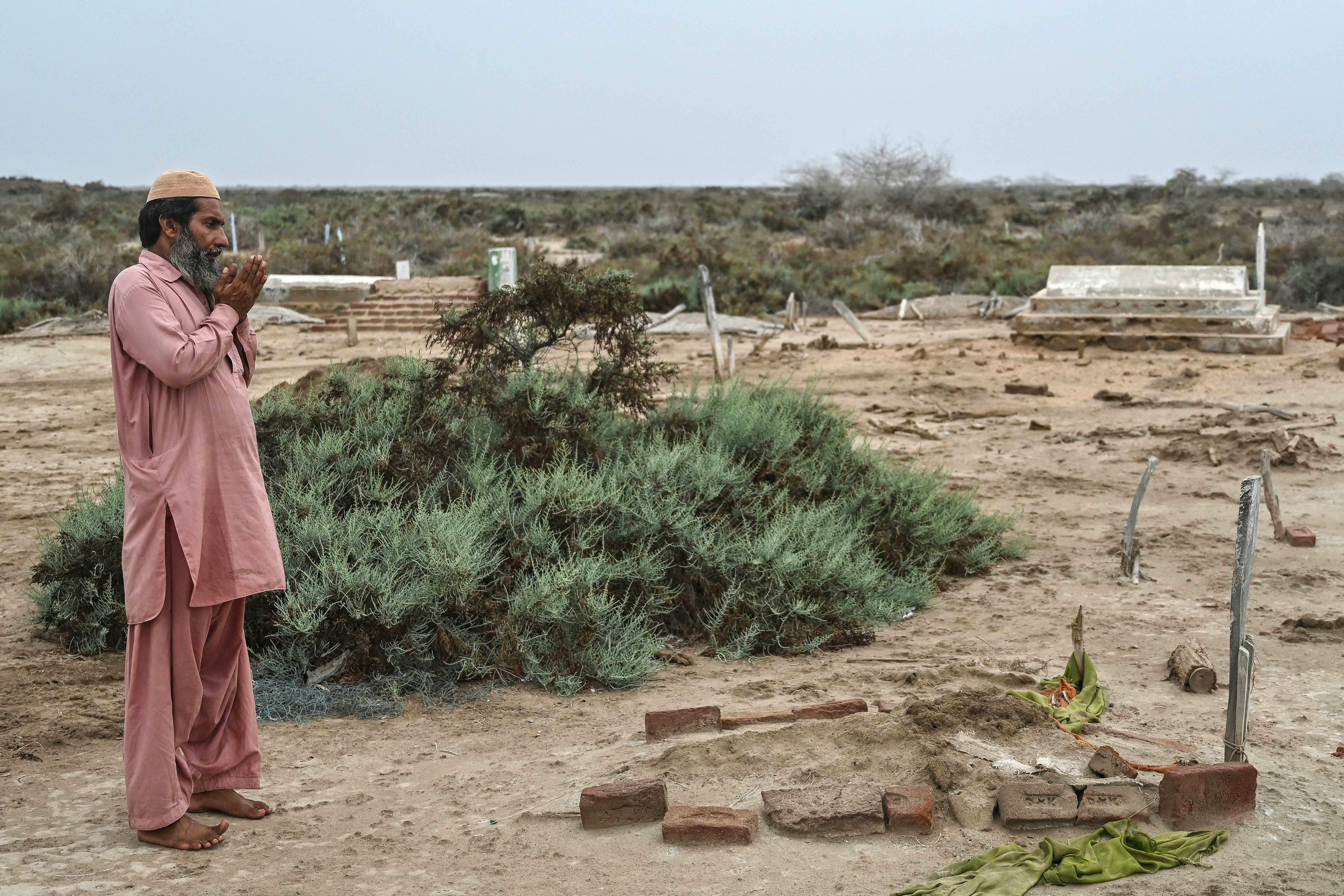Habibullah Khatti prays at his mother’s grave before abandoning Abdullah Mirbahar village