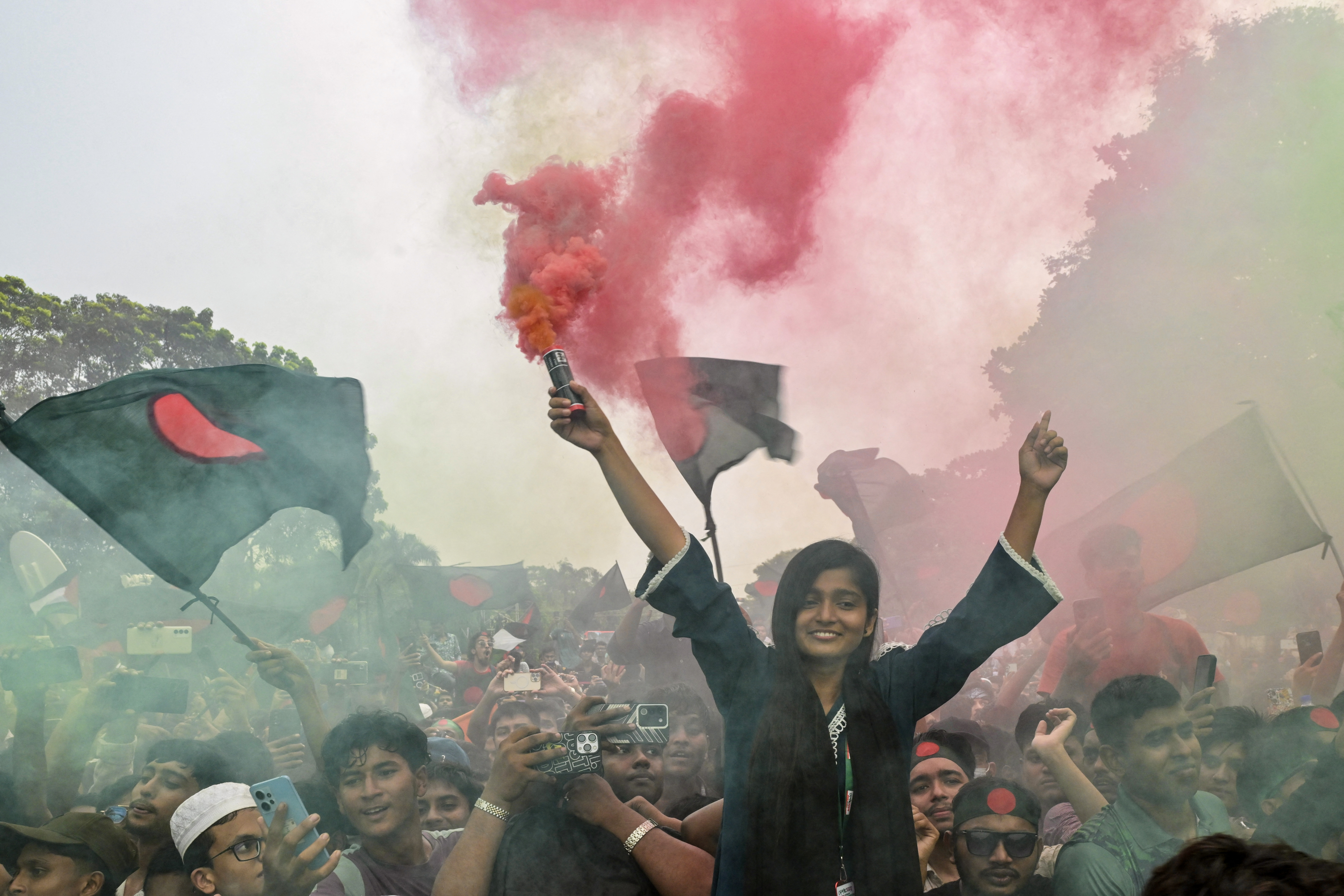 People hold Bangladesh's national flag as they celebrate during a government-organised event