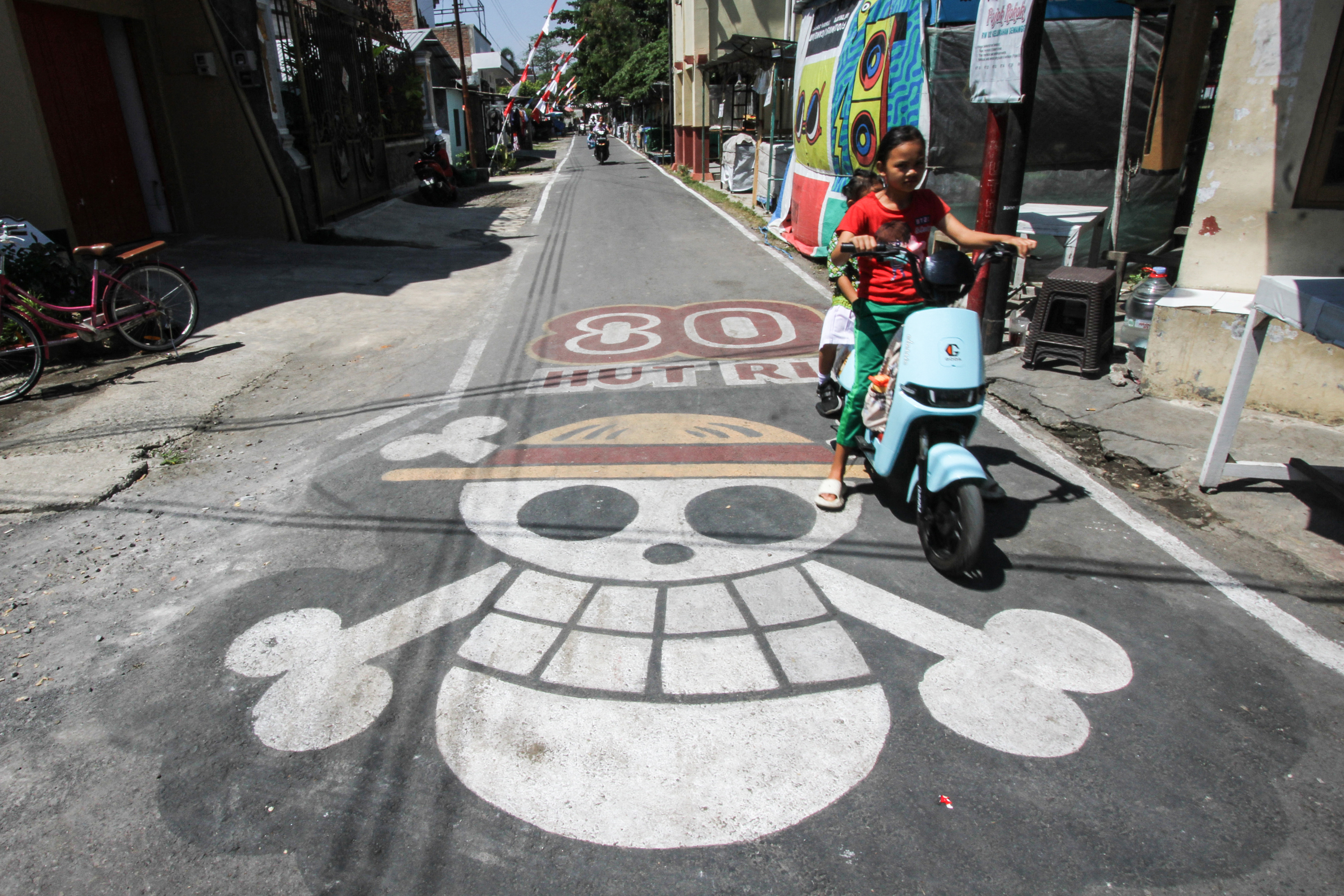 A graffiti of the pirate flag from Japanese anime One Piece, adopted by some Indonesians as a symbol of frustration with their government, is seen on a street in Sukoharjo, Central Java, on August 6, 2025, ahead of the countrys 80th Independence Day. As Indonesia's independence day approaches red and white flags will be flown across the country, but a viral anime pirate banner has drawn government threats against flying the swashbuckling ensign. A Jolly Roger skull and bone symbol topped with a straw hat from Japan's anime series 'One Piece' has caused concern among officials in Jakarta that it is being used to criticise President Prabowo Subianto's policies. (Photo by DIKA / AFP) / TO GO WITH 'INDONESIA-POLITICS-PROTEST-ANIME, FOCUS' BY DESSY SAGITA & JACK MOORE
