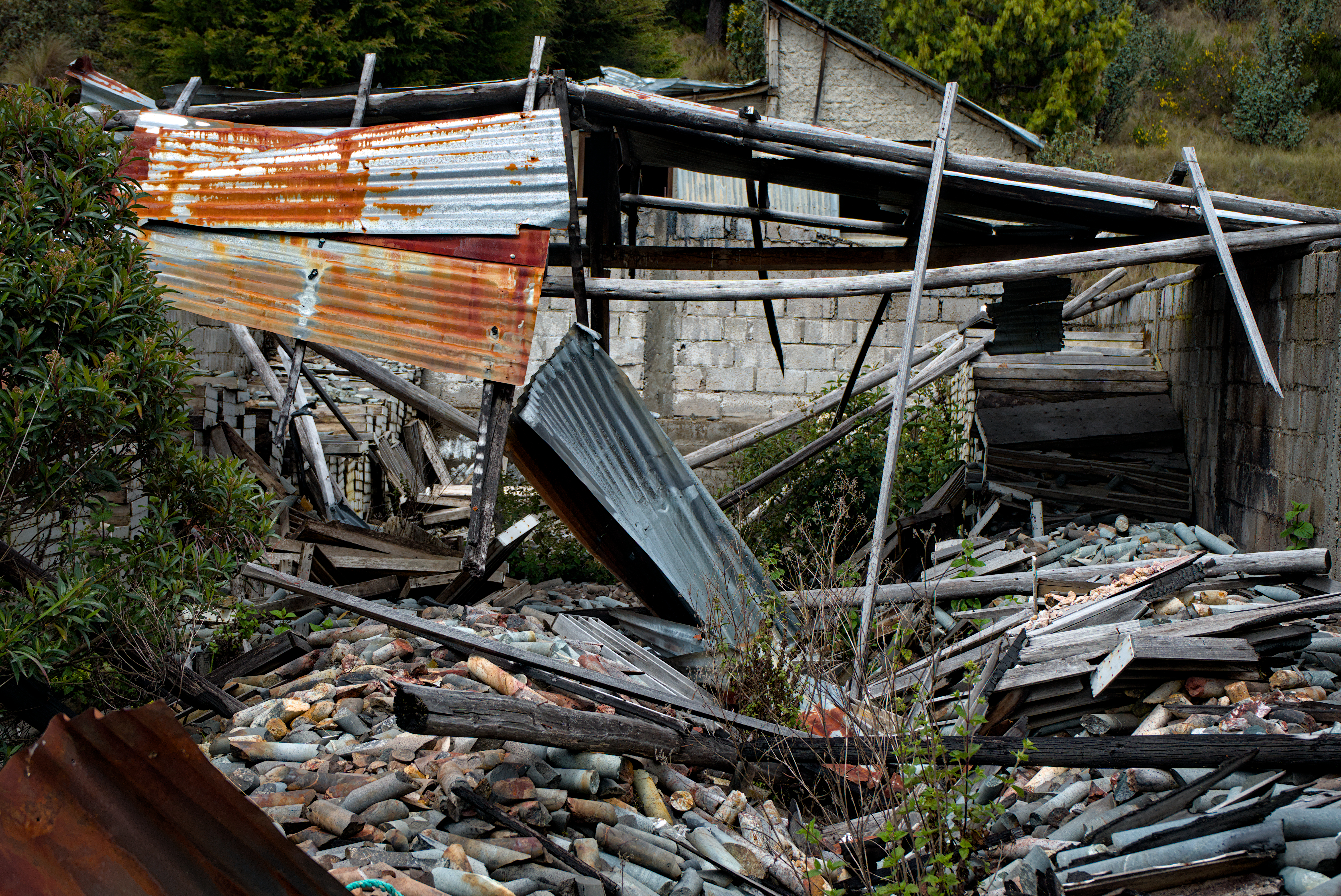 A rusted corrugated metal roof tumbles onto extracted mineral cores