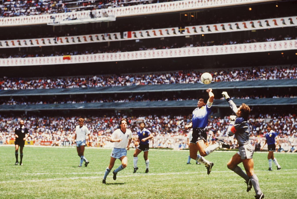 Diego Maradona of Argentina handles the ball past Peter Shilton of England to score the opening goal of the 1986 World Cup quarterfinal at the Azteca Stadium in Mexico City