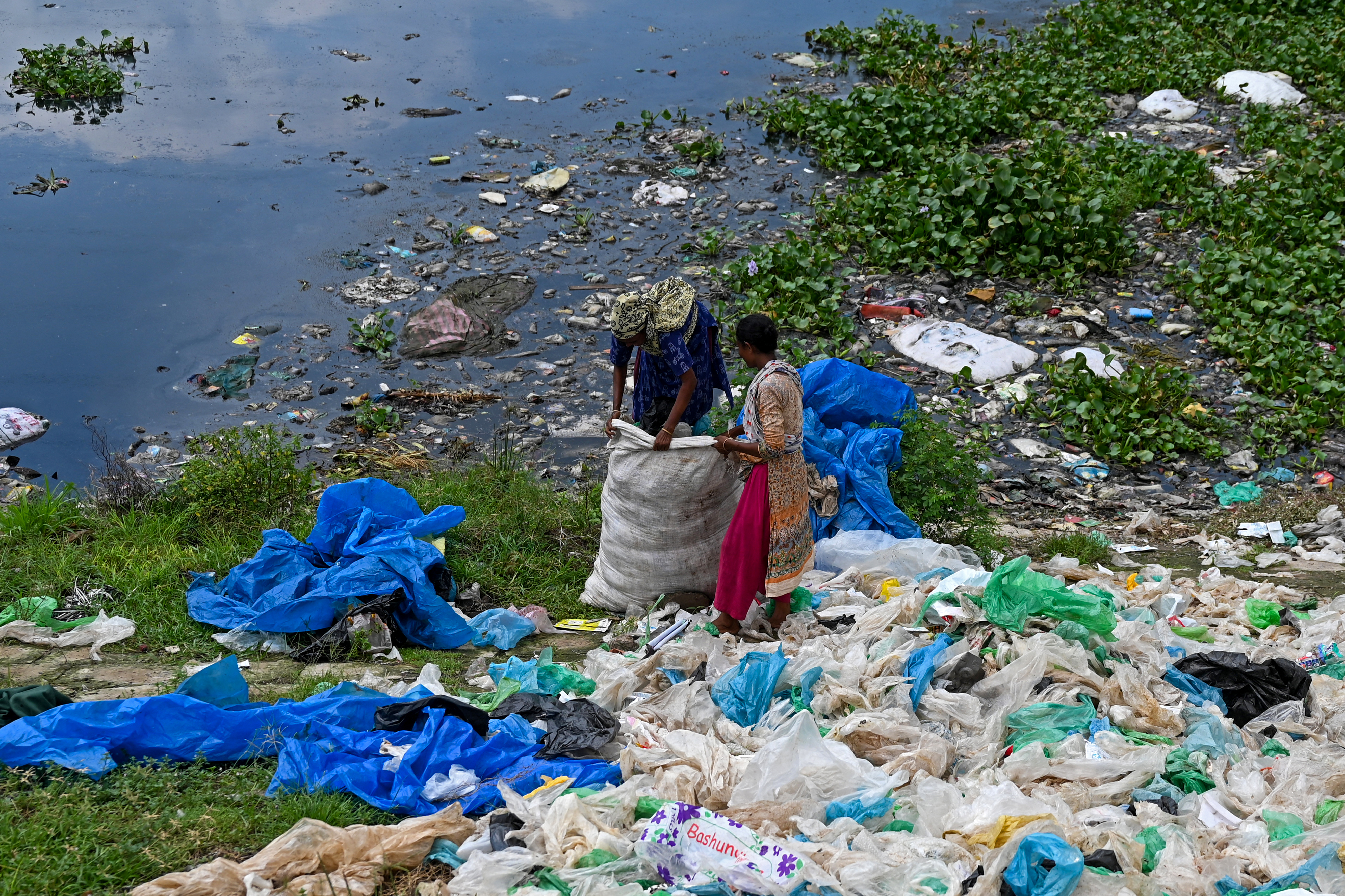 (FILES) Ragpickers sort plastic bags for recycling in Dhaka on September 8, 2024.