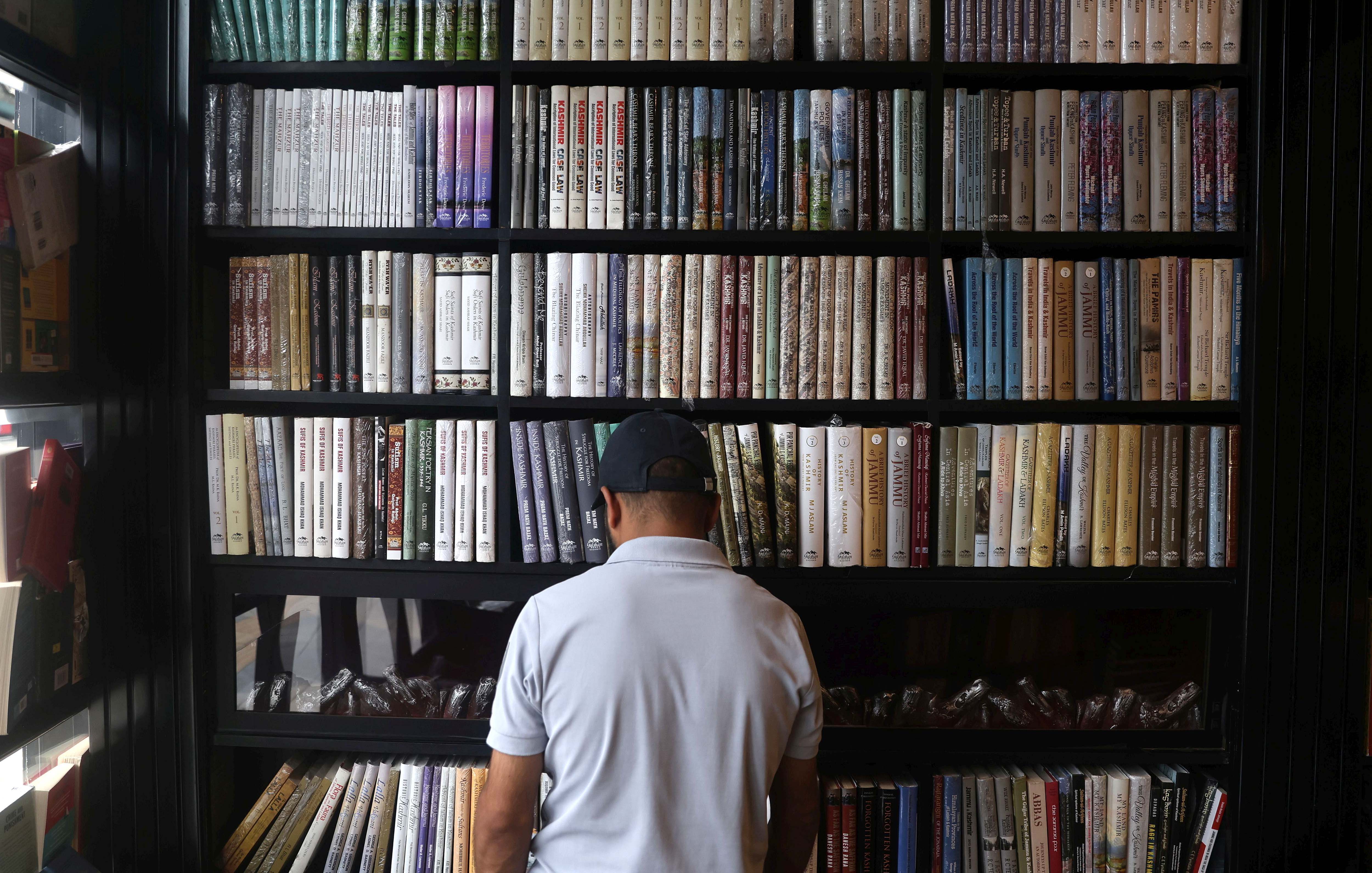 A man checks a book inside a book shop.