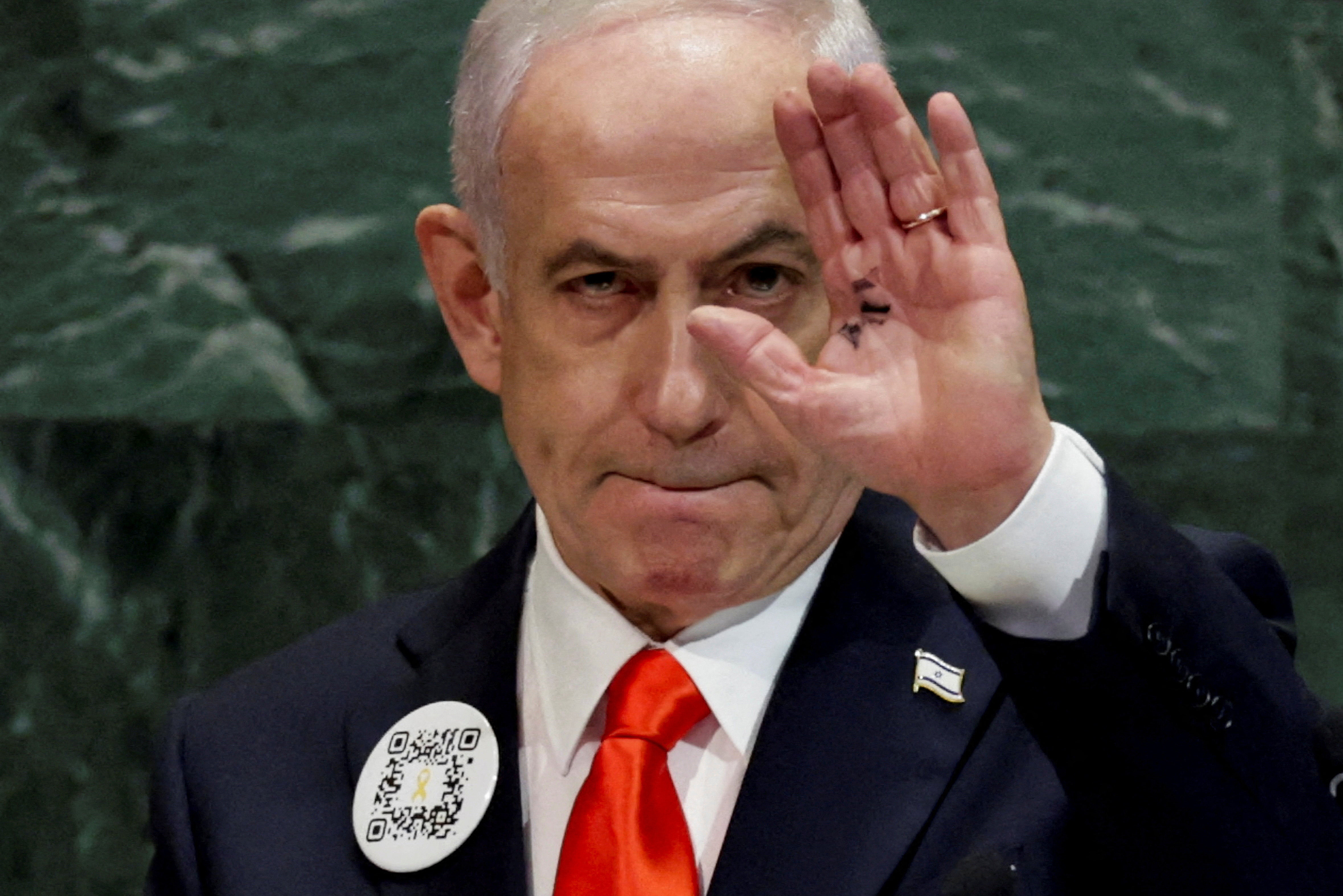 Israeli Prime Minister Benjamin Netanyahu raises his hand.
