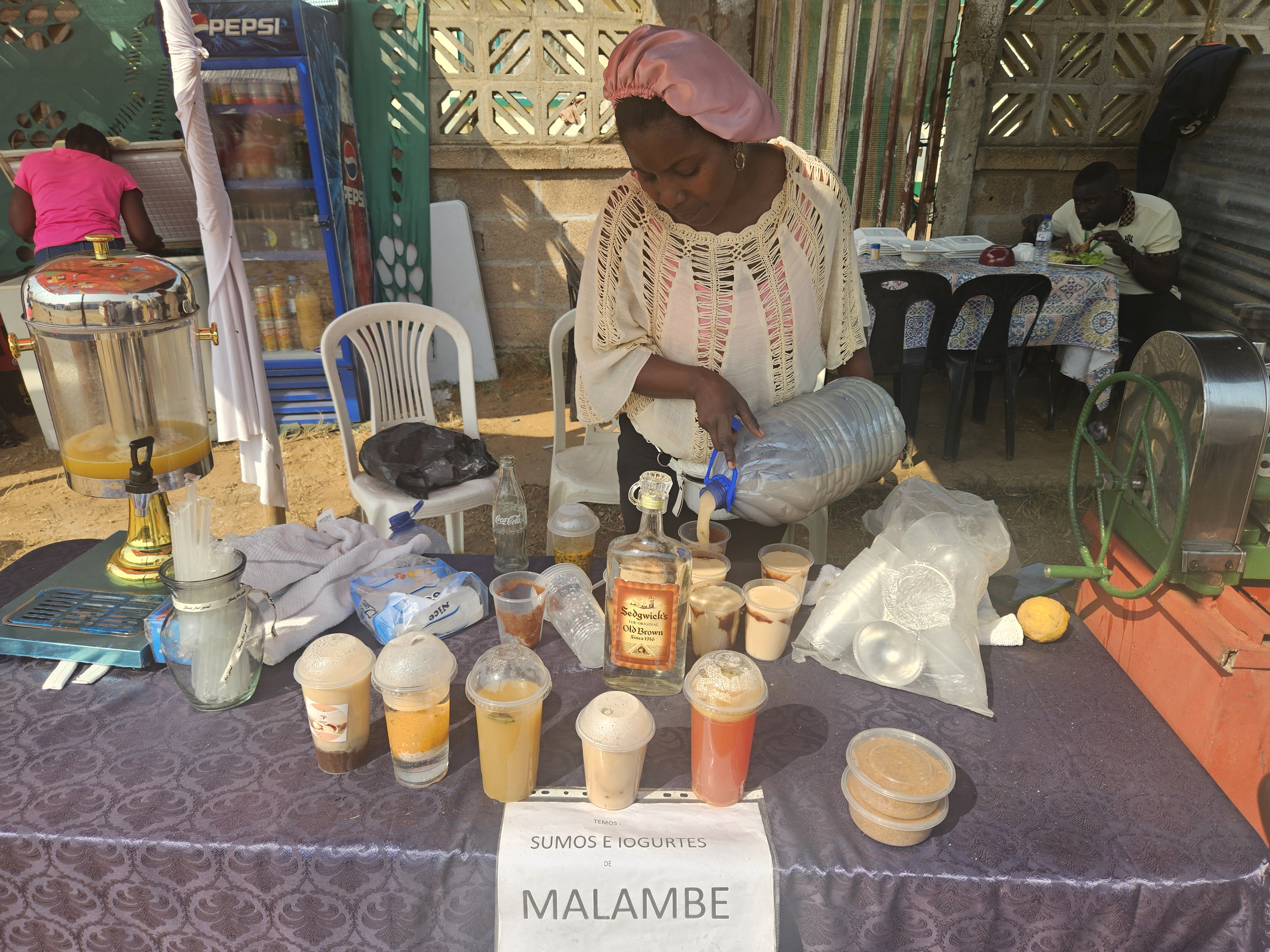 Vania Pessane, a businesswoman in Maputo, Mozambique, pours cups of malambe to sell to customers