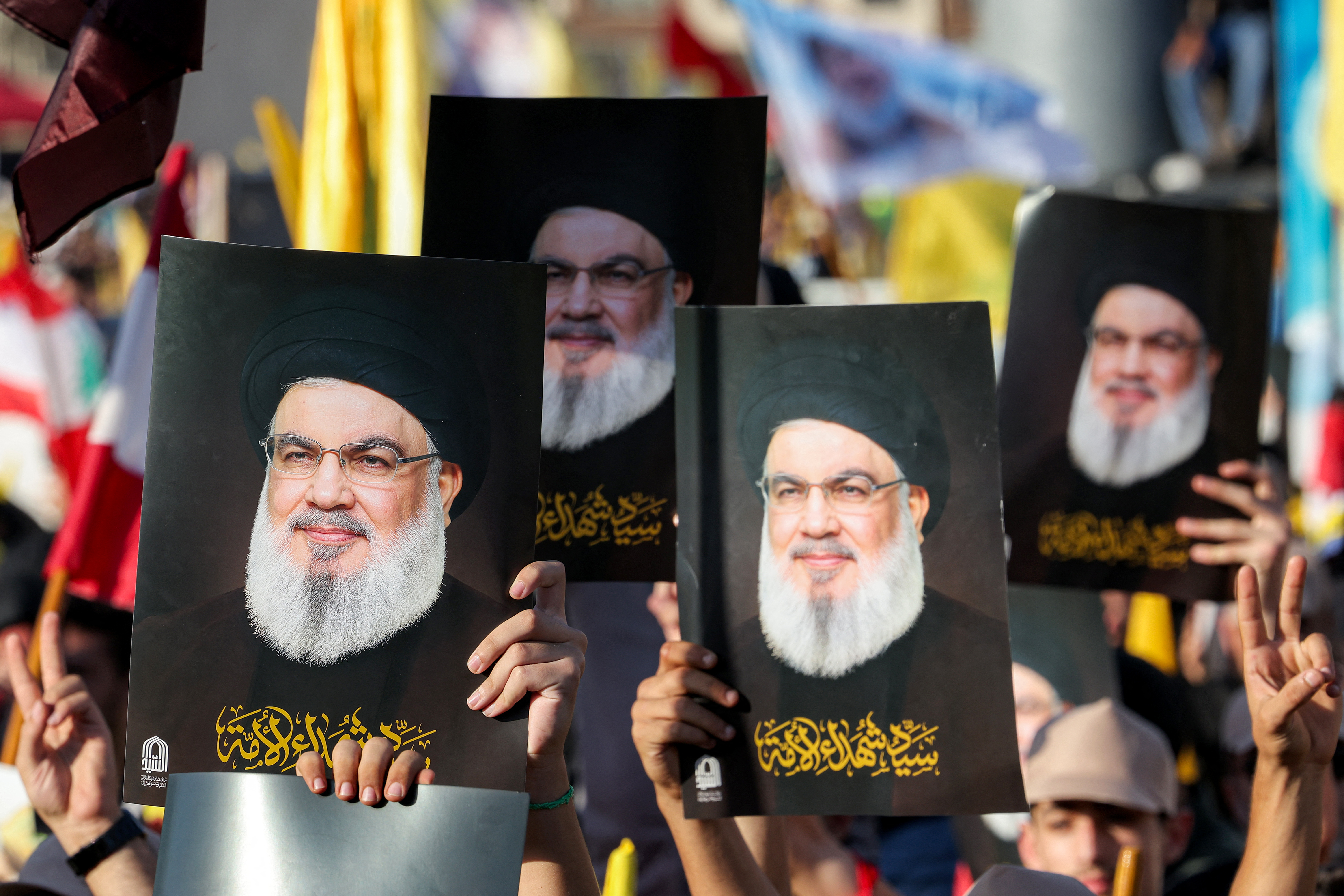 Supporters of the Lebanese Shiite movement Hezbollah hold pictures of their slain longtime leader Hassan Nasrallah during a ceremony marking the first anniversary of Israel's assassination of Nasrallah, in Beirut's southern suburbs on September 27, 2025.