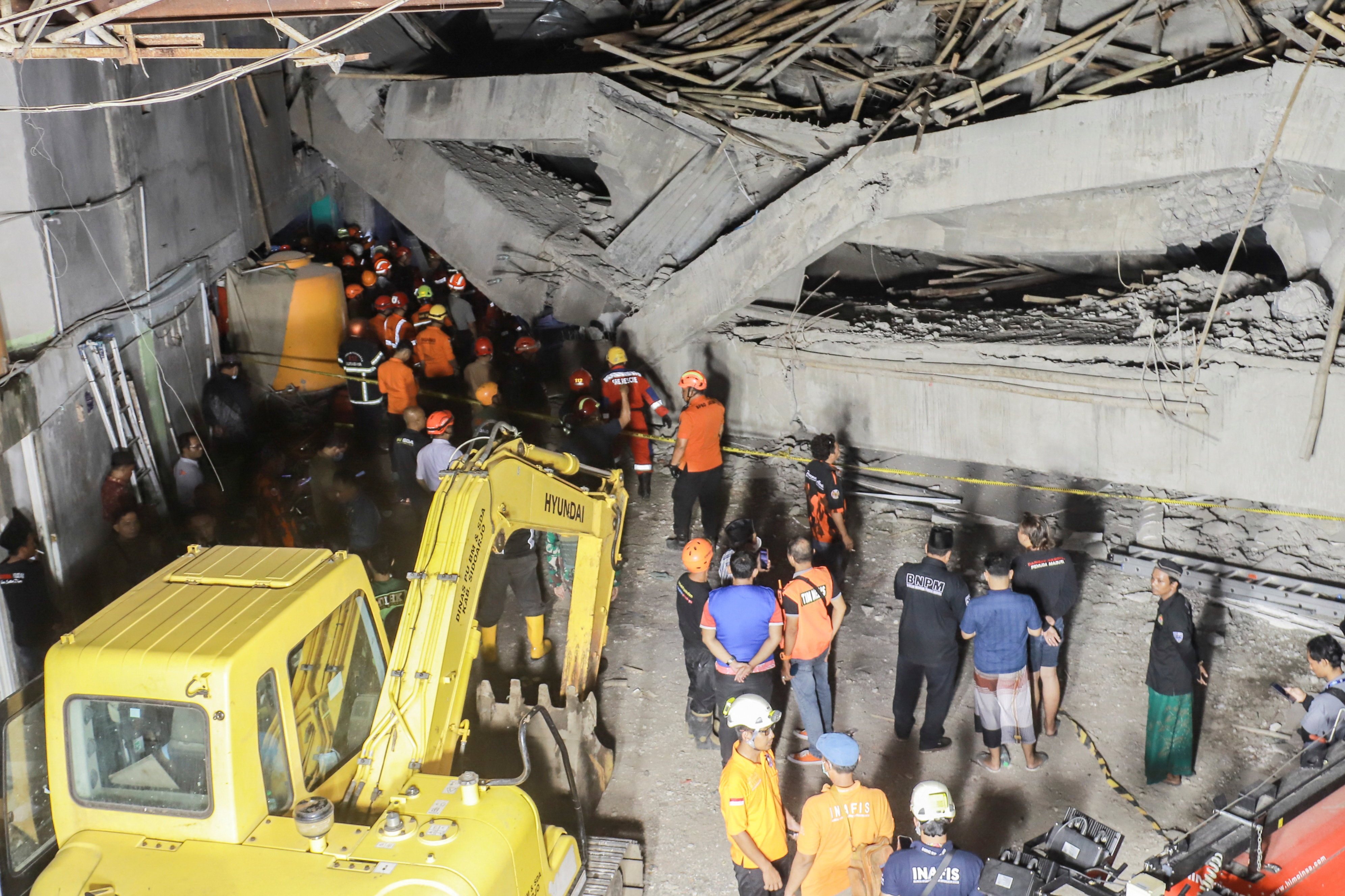 Search and rescue officers search for victims amidst the rubble of a collapsed building