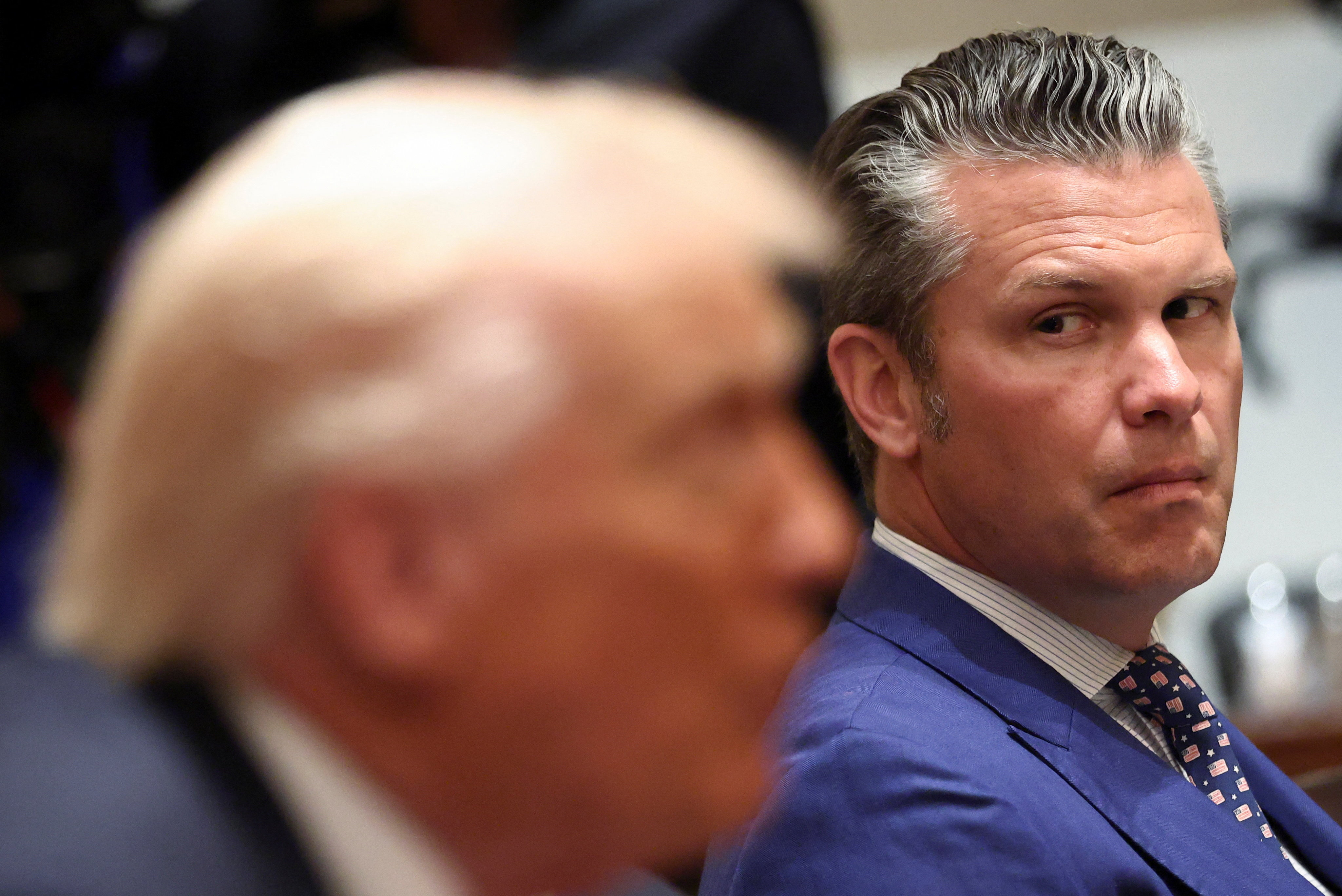 Pete Hegseth looks over at Trump