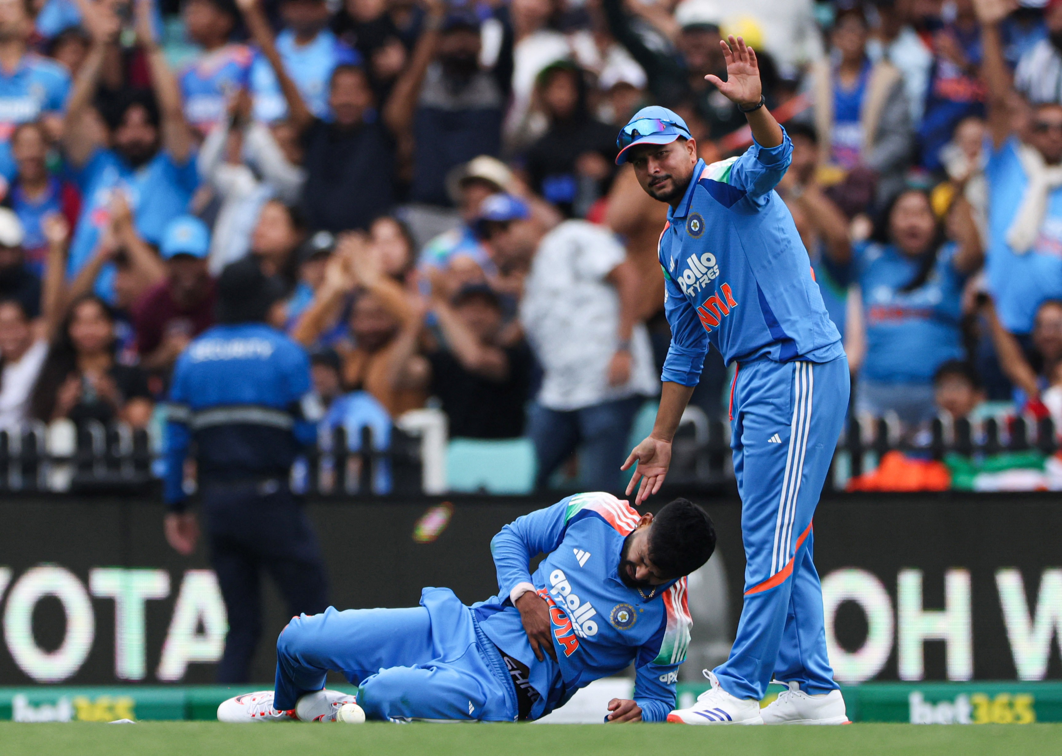 India’s Shreyas Iyer holds his side after taking a catch to dismiss Australia’s Alex Carey as India’s Kuldeep Yadav calls for help