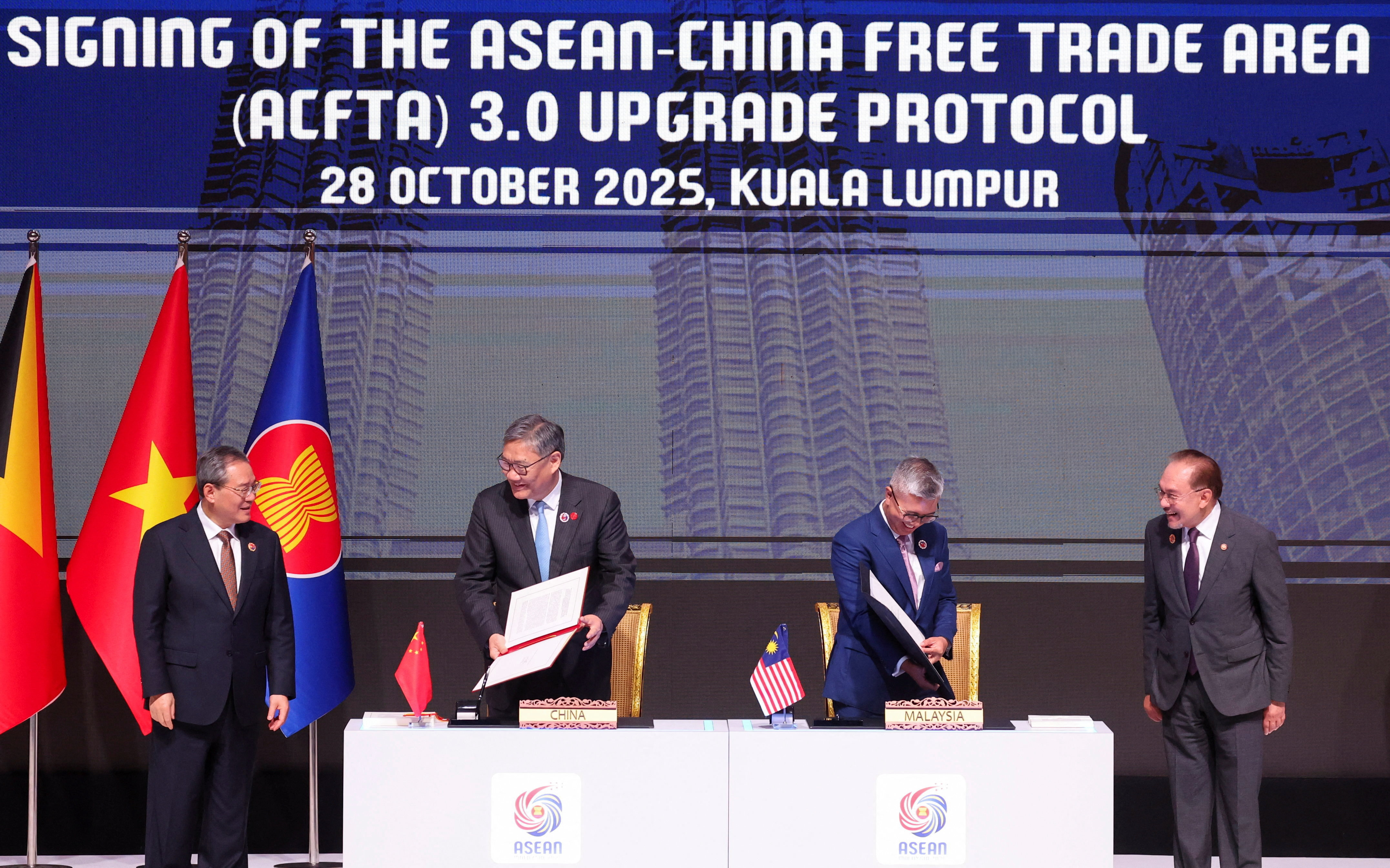 Chairman of the Association of Southeast Asian Nations (ASEAN) and Malaysia's Prime Minister, Anwar Ibrahim and Chinese Premier Li Qiang witness the signing of the ASEAN-China Free Trade Area 3.0 Upgrade signed by Malaysia Trade Minister and ASEAN Economic Minister Chairman Tengku Zafrul Aziz and Chinese Commerce Minister Wang Wentao ahead of the 28th ASEAN–China Summit, held as part of the 47th ASEAN Summit in Kuala Lumpur, Malaysia October 28, 2025.