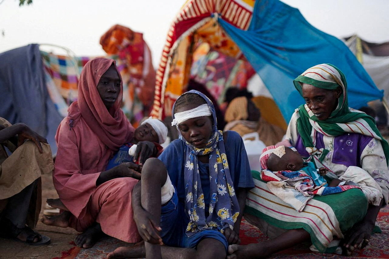 A family while sitting at a camp for displaced people who fled from el-Fasher to Tawila [Mohammed Jamal/ Reuters]