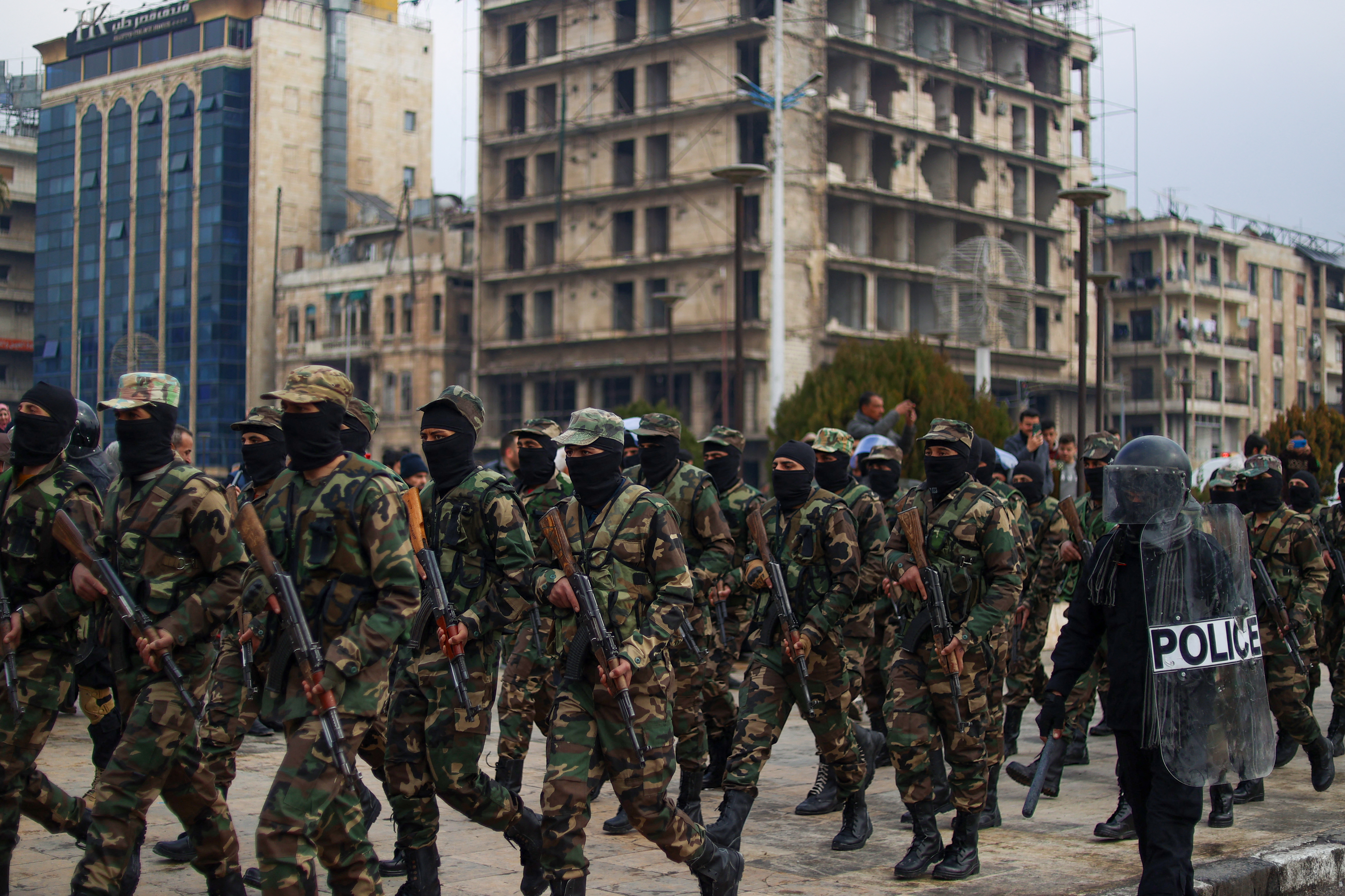 Armed and masked soldiers attend a ceremony.