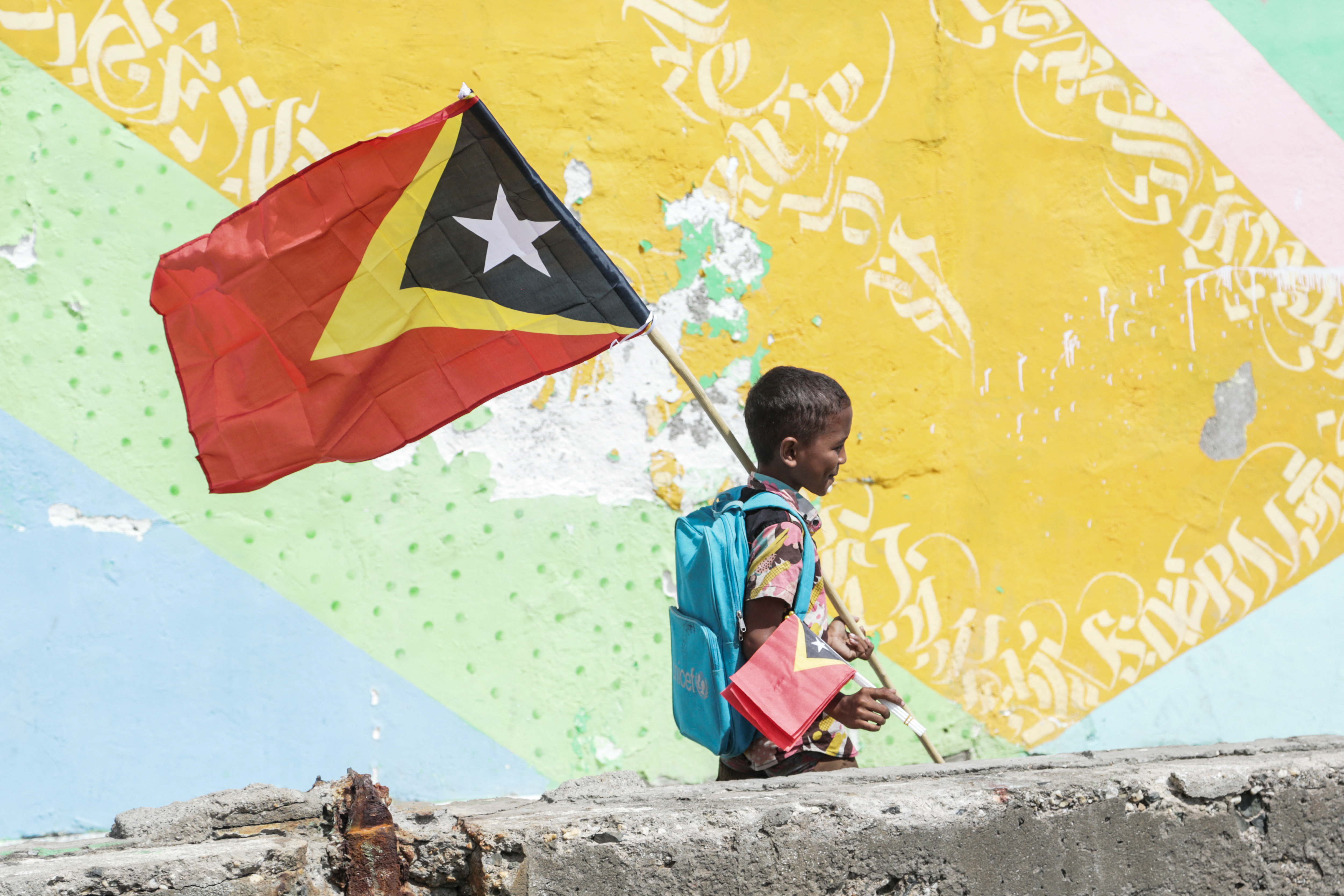 A boy holds East Timors national flag as the country celebrates the 23rd anniversary of Independence Day in Dili on May 20, 2025. (Photo by Valentino Dariell DE SOUSA / AFP)