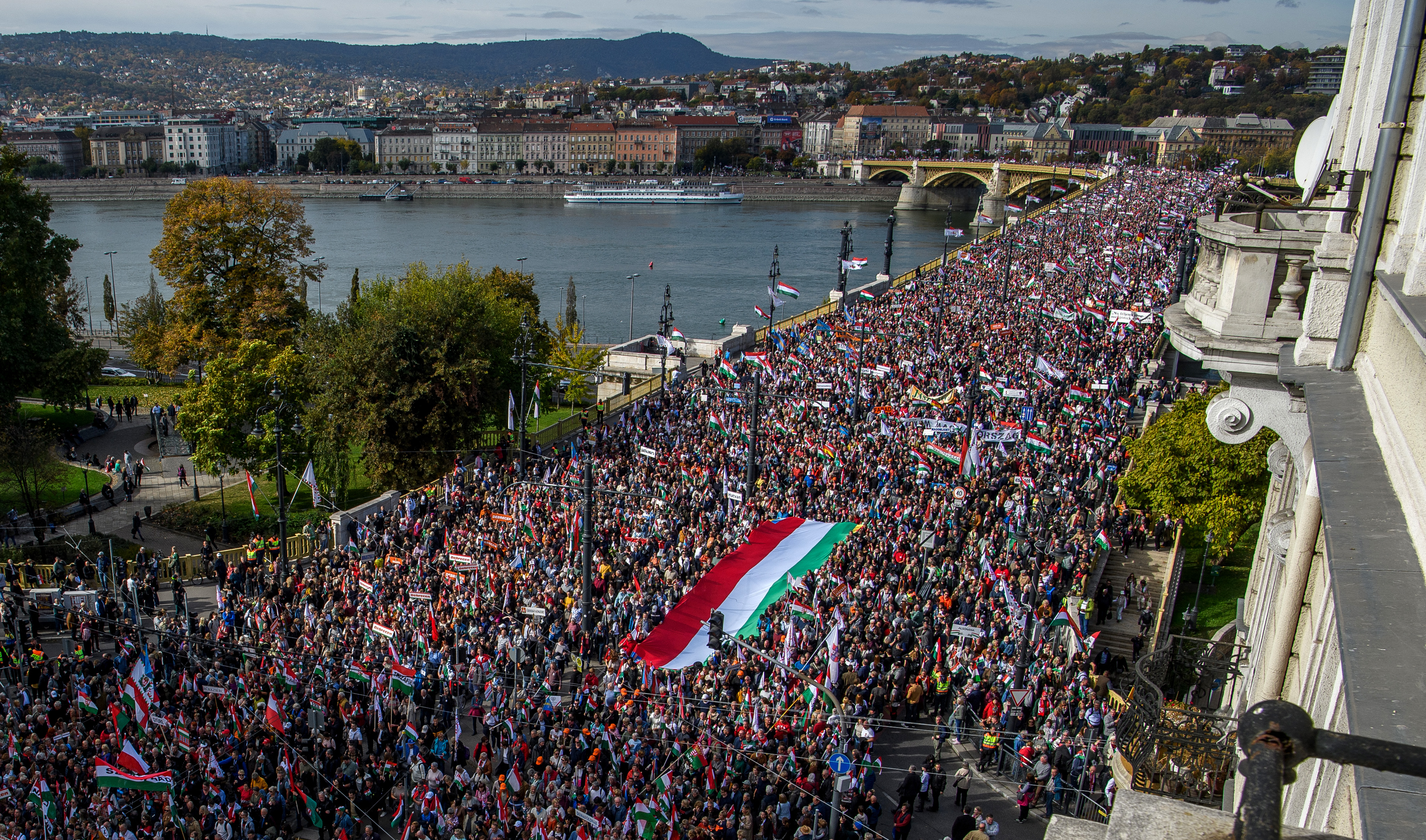 Demonstrators carry a huge Hungarian flag as they take part in a "Peace March" in Budapest, Hungary