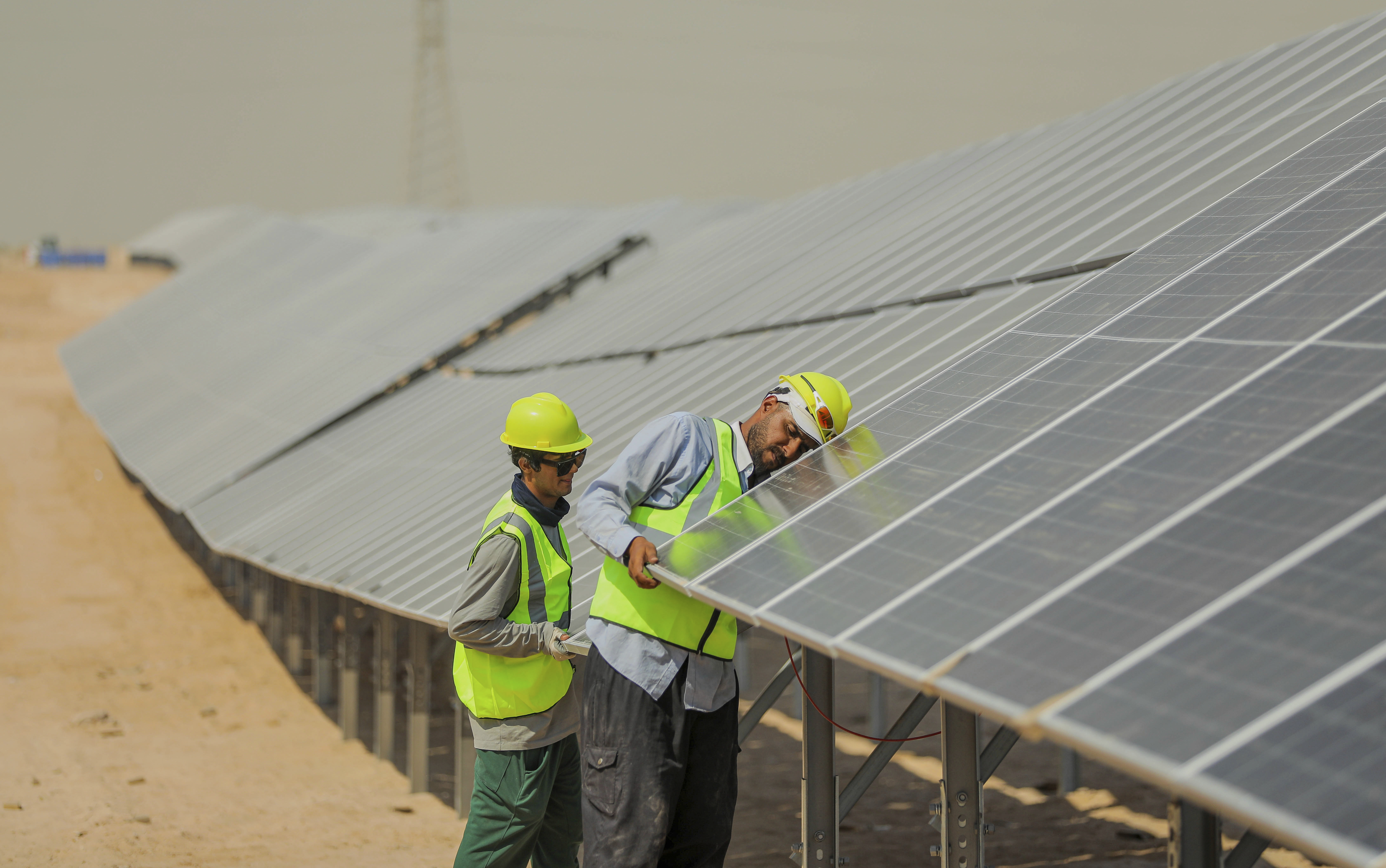 Workers install panels at a newly opened industrial-scale solar power plant in Karbala, Iraq, Wednesday, Sept. 17, 2025. (AP Photo/Anmar Khalil)