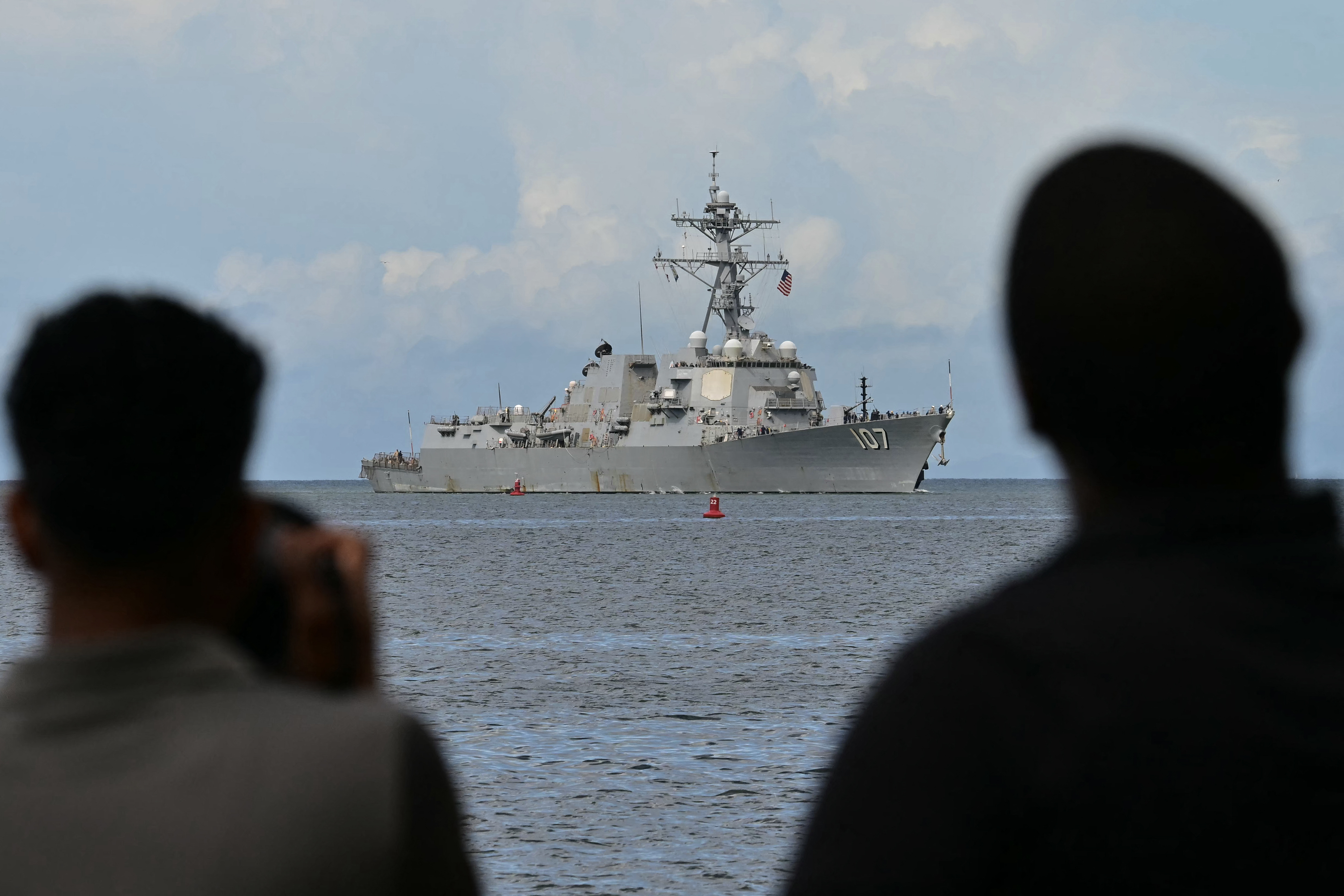 Photographers take pictures as the USS Gravely warship enters the port of Port of Spain on October 26, 2025.