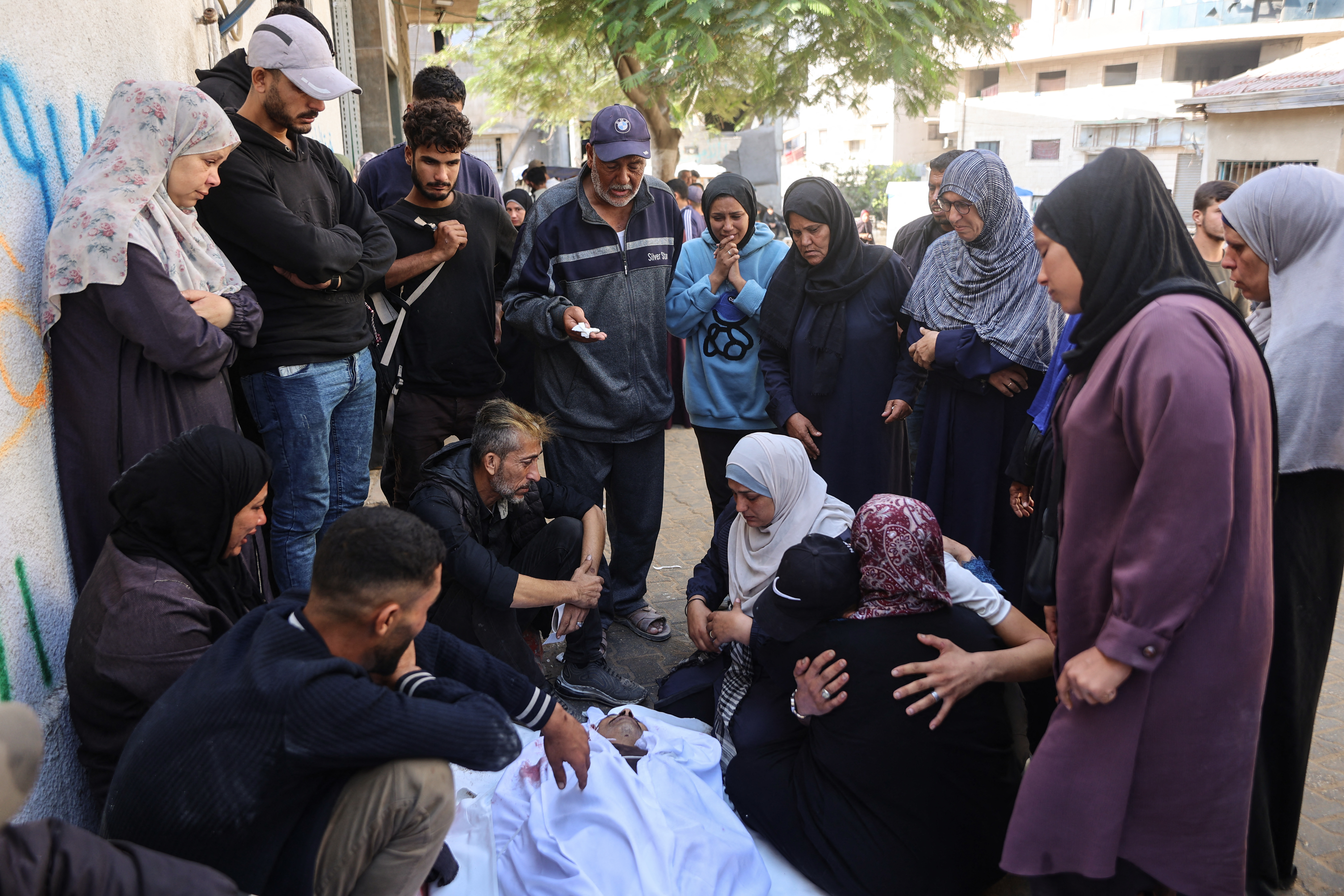 EDITORS NOTE: Graphic content / Palestinians mourn over the body of a relative who was killed in overnight Israeli strikes, at the Al-Shifa Hospital in Gaza City on October 29, 2025.