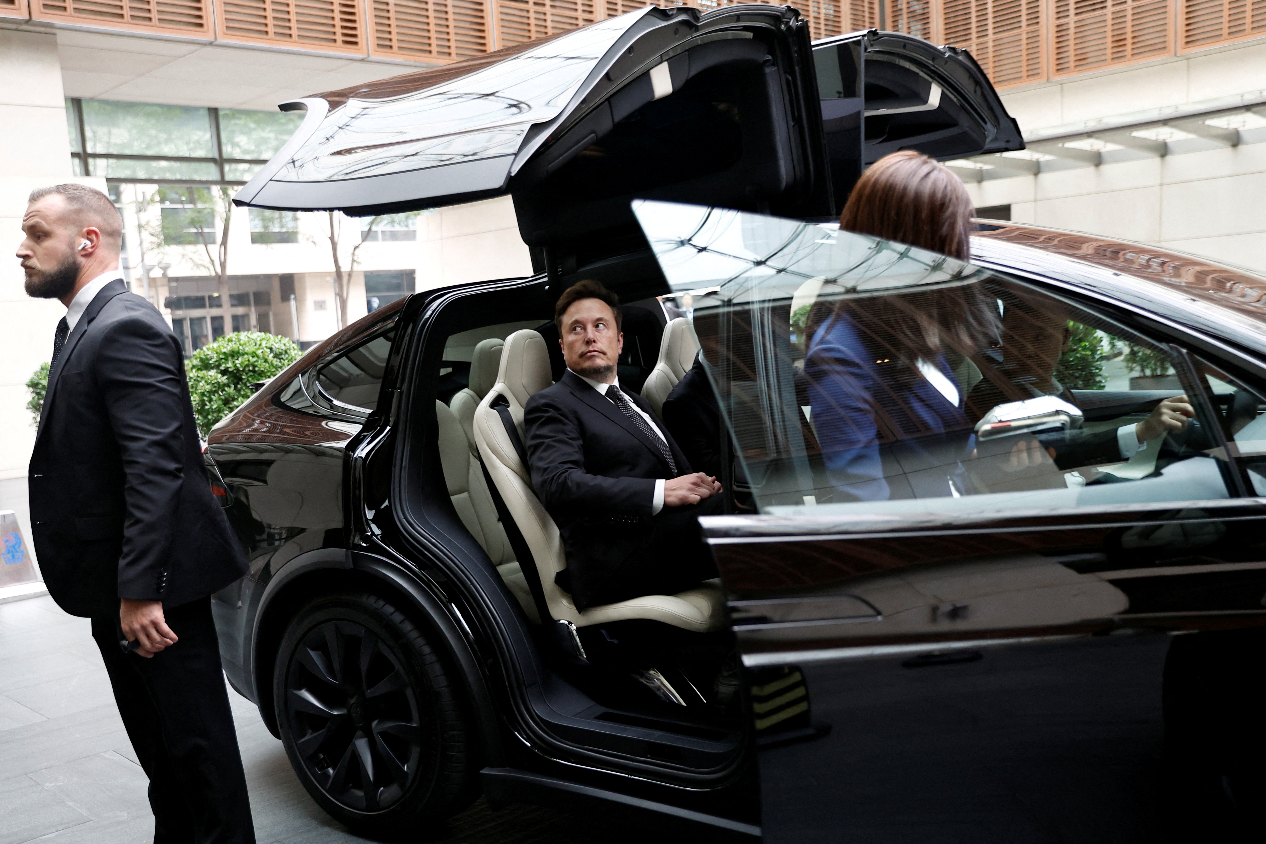 Tesla CEO Elon Musk gets into a Tesla car as he leaves a hotel in Beijing, China, on May 31, 2023