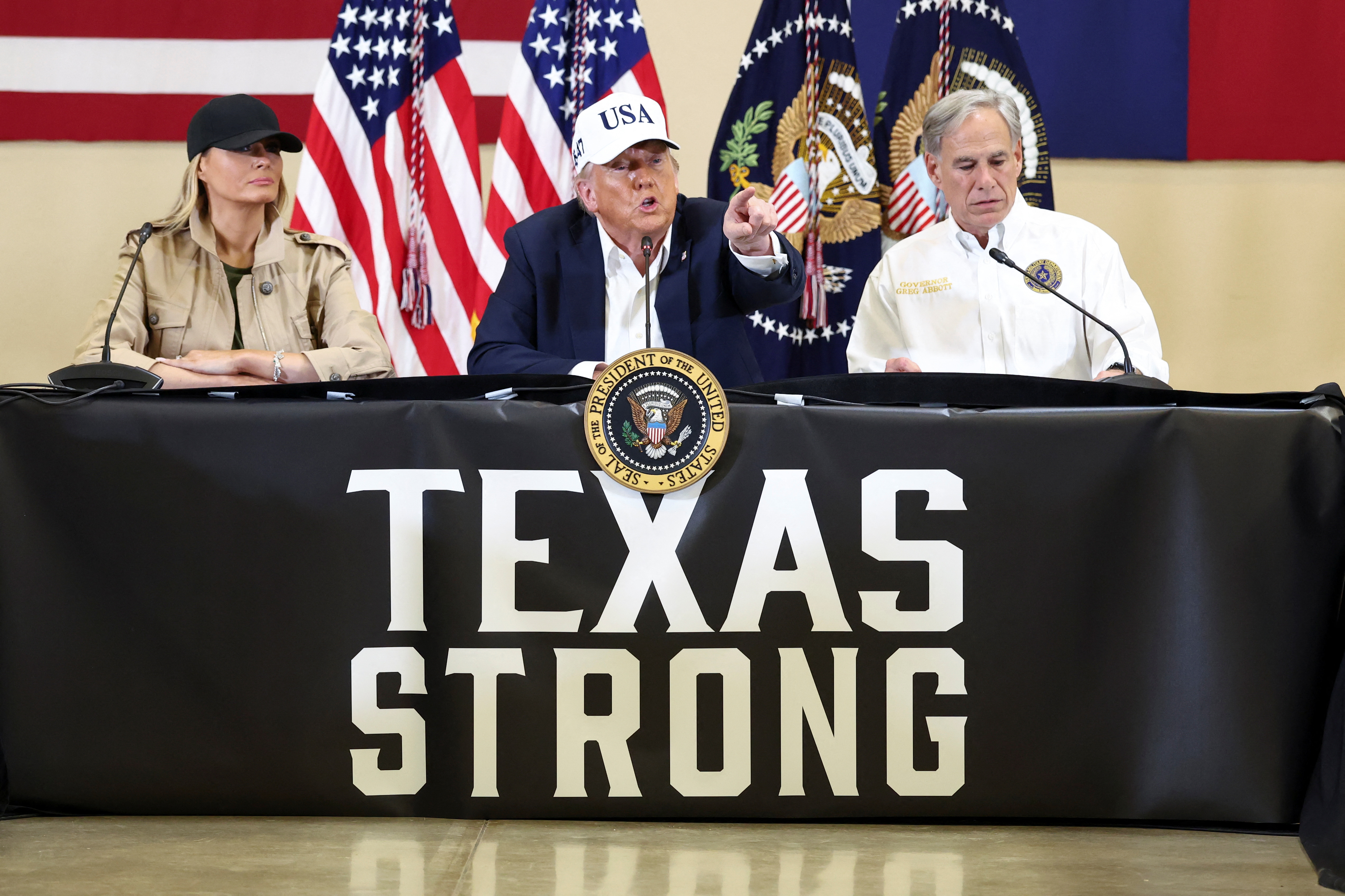 U.S. President Donald Trump, first lady Melania Trump and Texas Governor Greg Abbott participate in a roundtable with first responders and local officials, at Hill Country Youth Center, in Kerrville, Texas, U.S., July 11, 2025. REUTERS/Kevin Lamarque