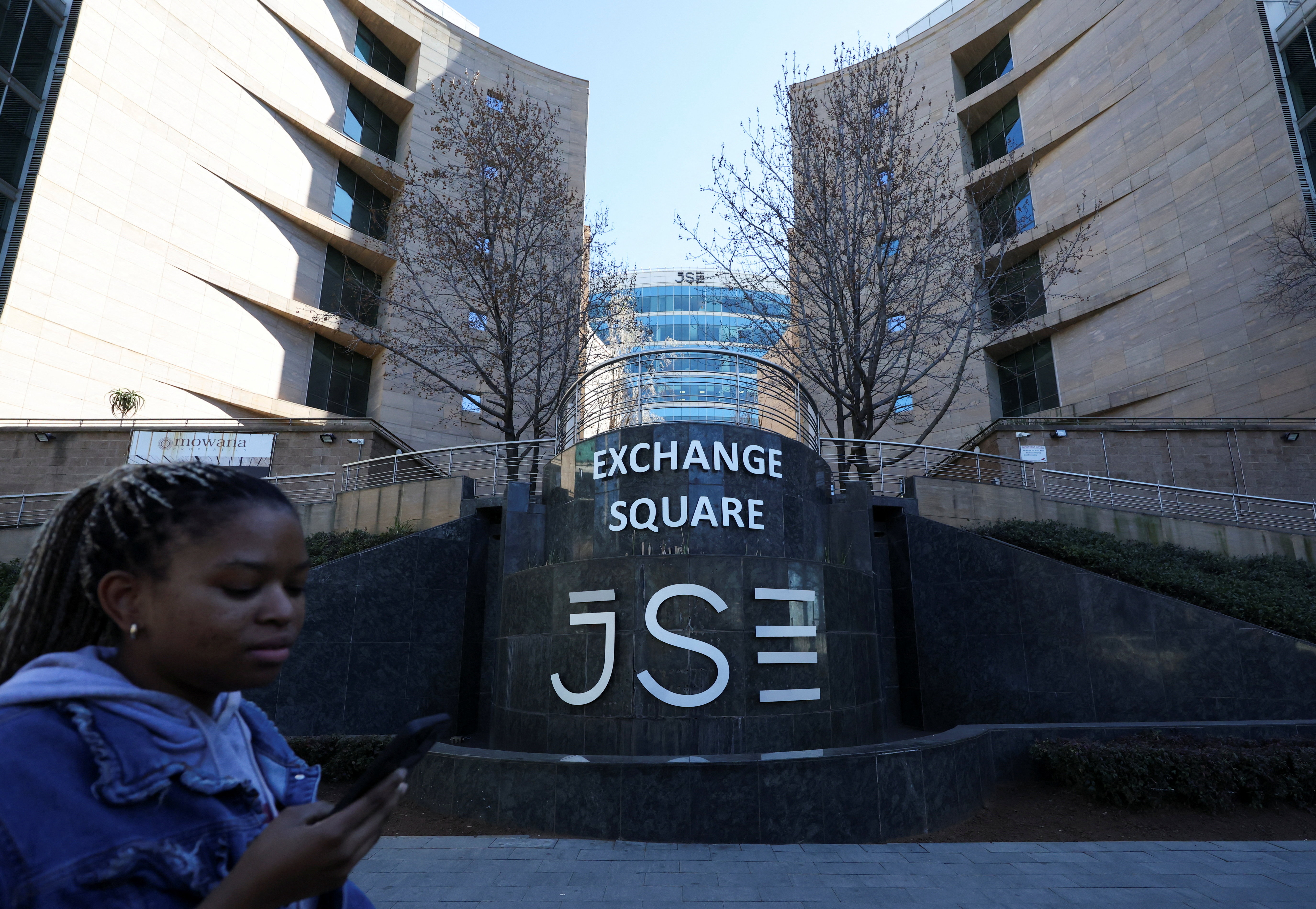 A woman walks at the Johannesburg Stock Exchange (JSE), in Sandton, South Africa, August 1, 2025. REUTERS/Siphiwe Sibeko