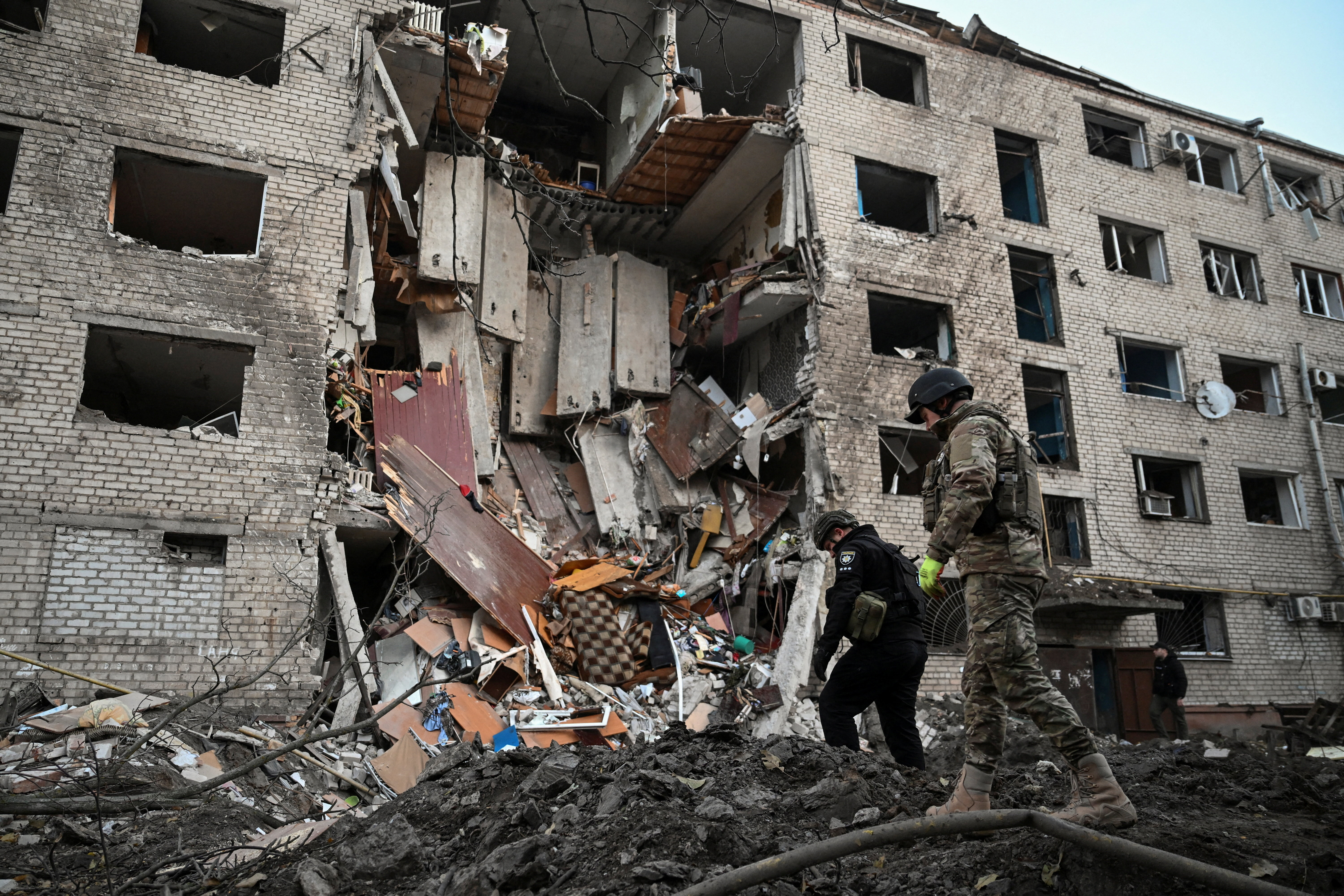 Investigators inspect debris at the site of a dormitory building damaged by Russian missile and drone strikes in Zaporizhzhia, Ukraine